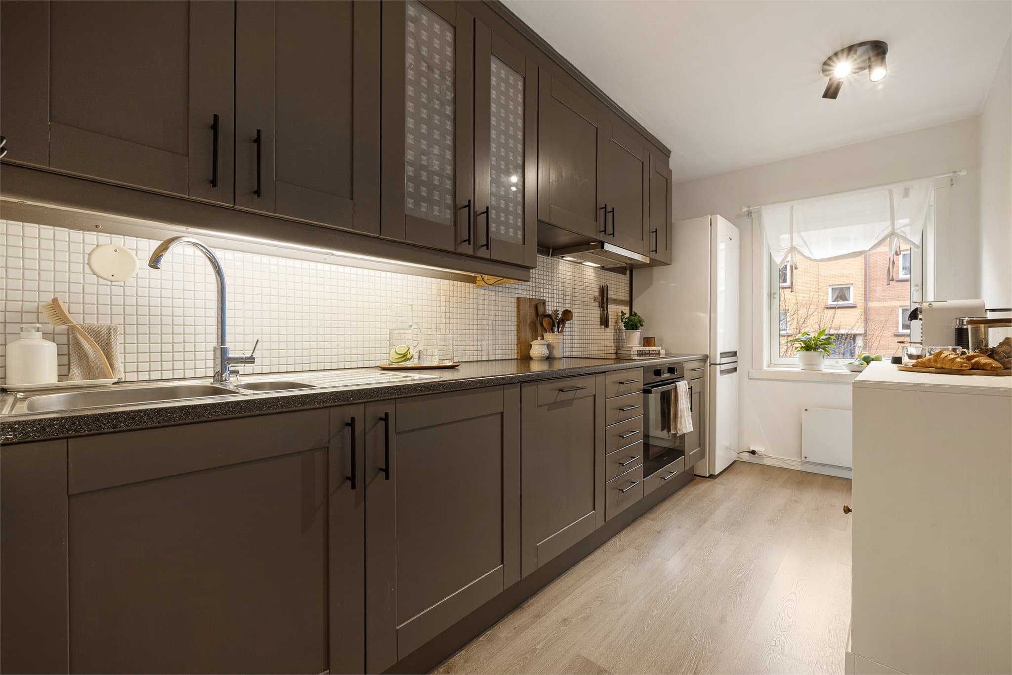 Leiligheten har et romslig og stilrent kjøkken som ligger i et eget rom, adskilt fra stuen. Dette gir en praktisk og funksjonell planløsning med gode arbeidsflater og god plass til matlaging.