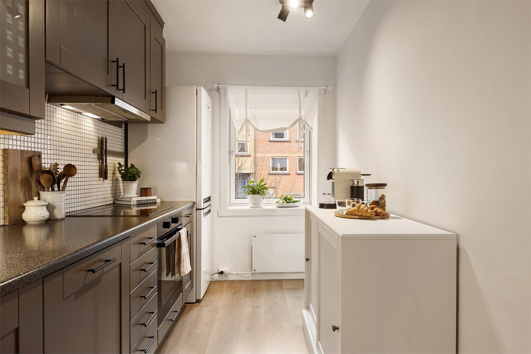 Den store vindusflaten gjør at kjøkkenet oppleves lyst og luftig.