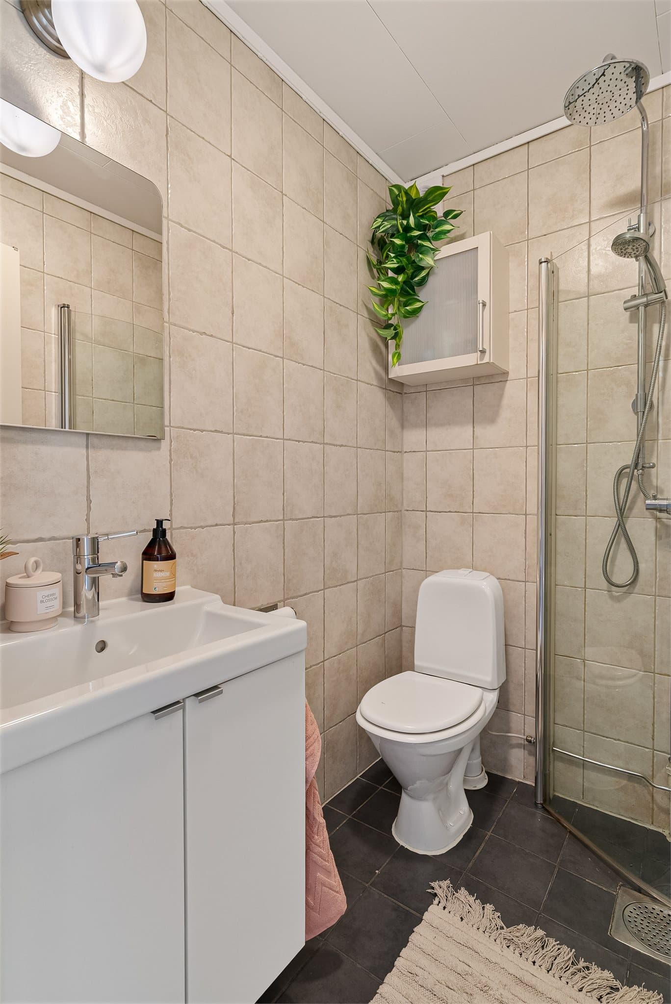 Baderommet er utstyrt med servantinnredning, toalett og dusjhjørne. Badet er flislagt og har varme i gulv.