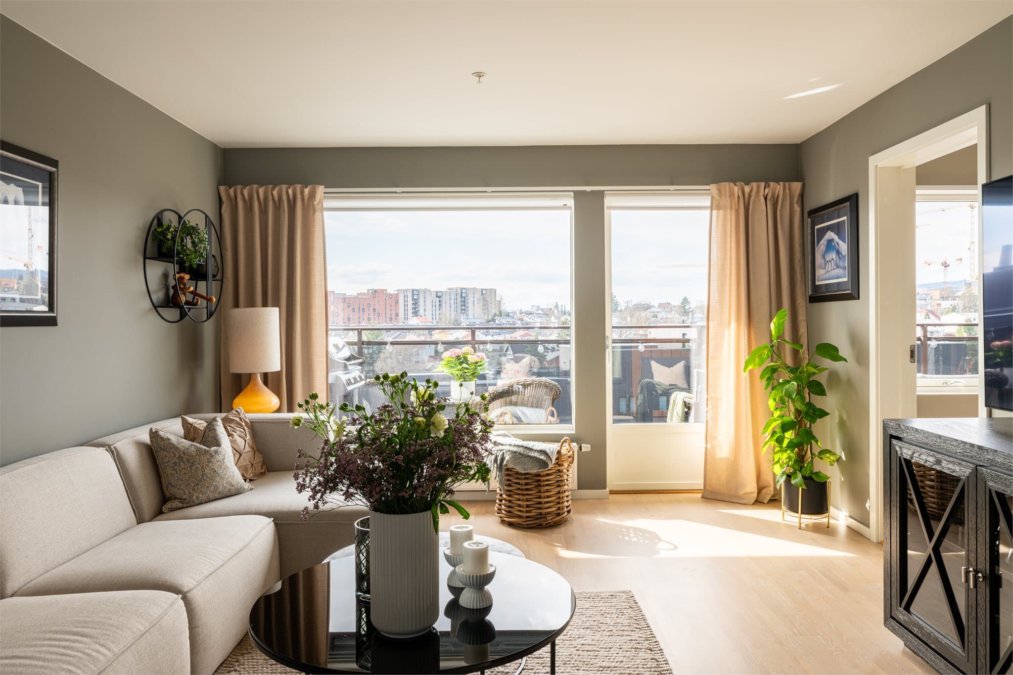 En romslig stue med fri utsikt og god plass til stor sofa med tilhørende stoler/kommode.