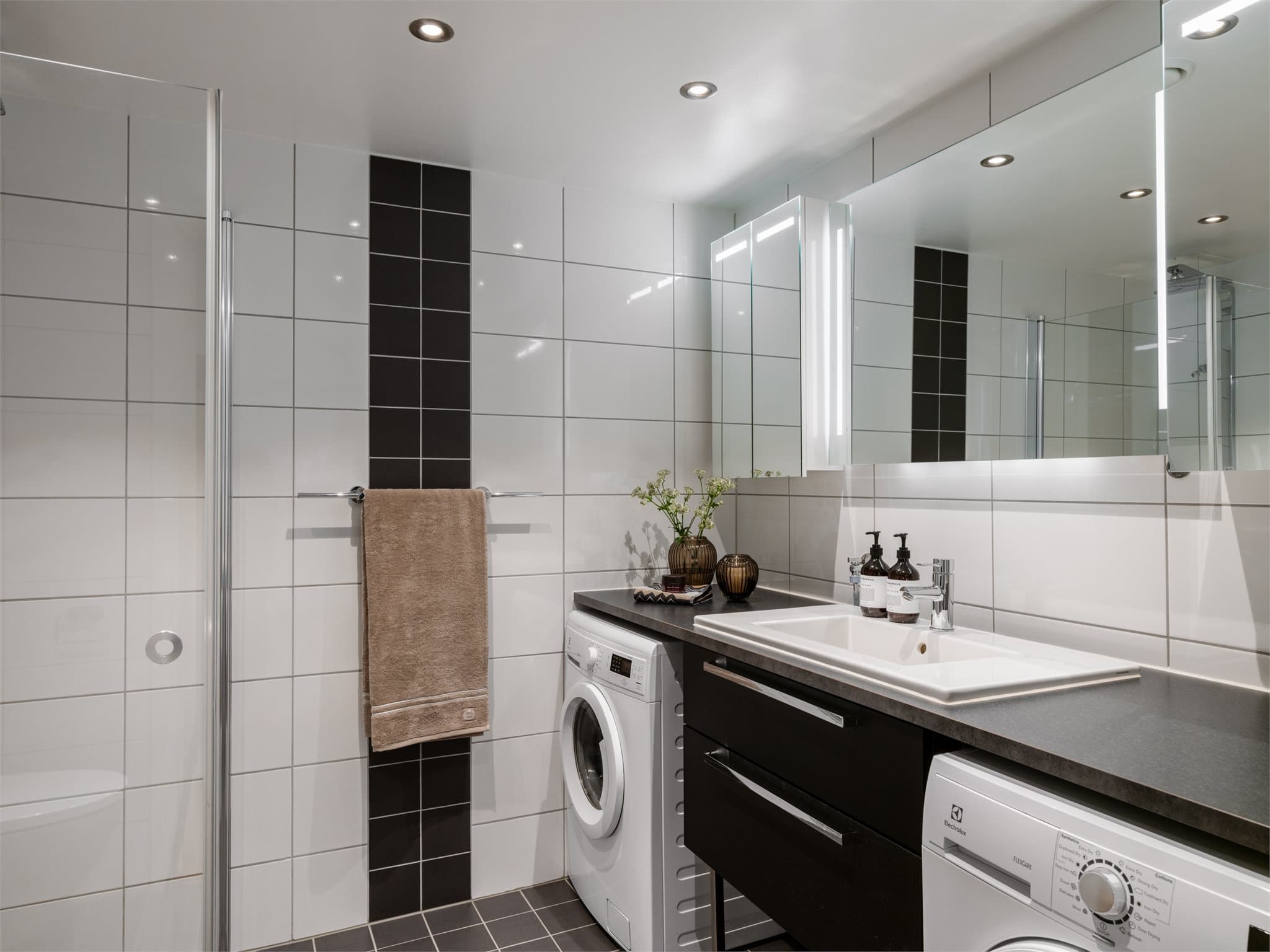 Det er montert to speilskap (en til hver) og opplegg for vaskemaskin og tørketrommel under en pen benkeplate. Så her ligger alt til rette for orden og system.