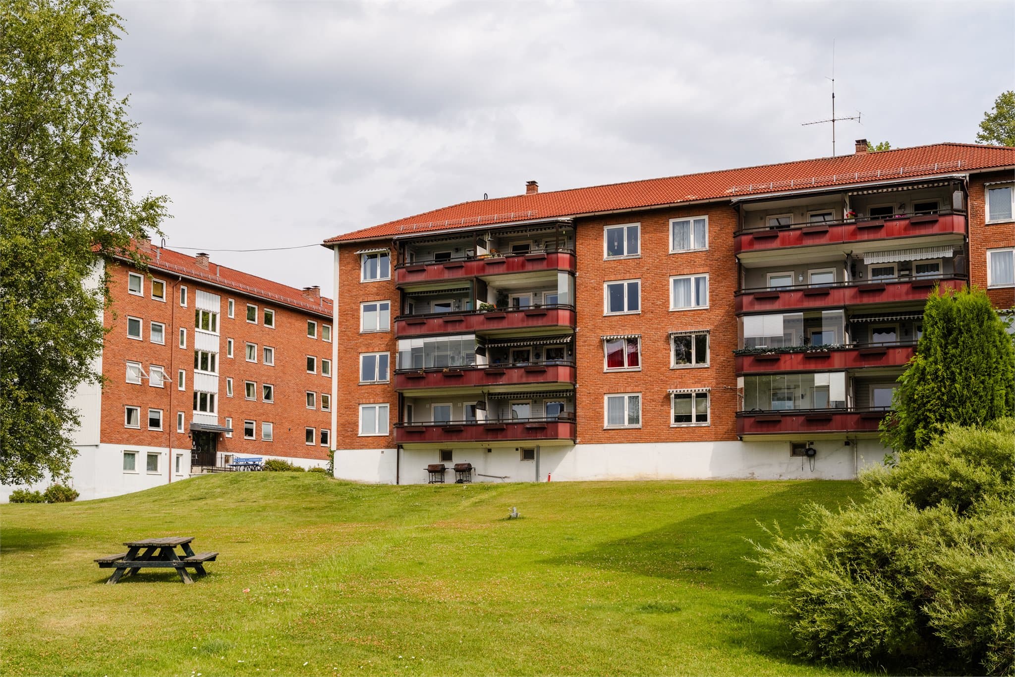 Bygget har teglfasader og ligger i rolige, grønne omgivelser.