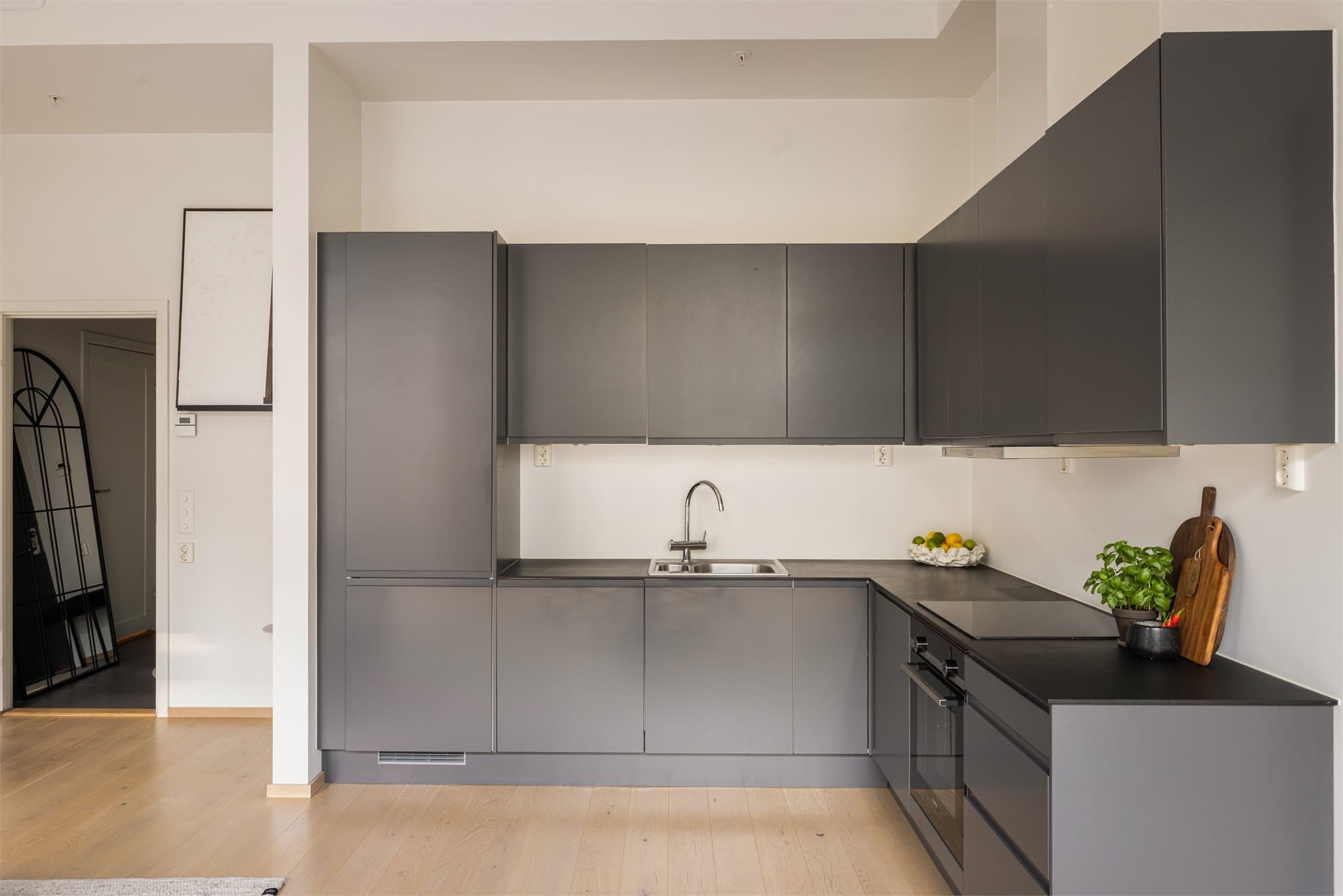 Leiligheten har et moderne Sigdal kjøkken med glatte fronter og laminat benkeplate.