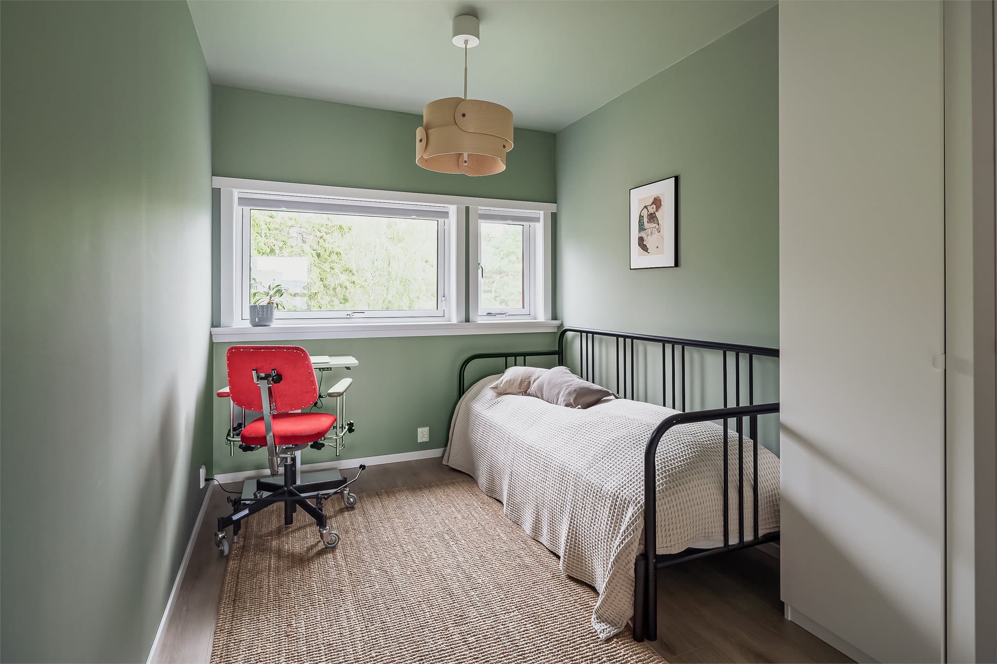 Boligens andre soverom med hyggelig utsyn mot grøntområdet. Her er det god plass til blant annet seng, nattbord og annet ønsket møblement.