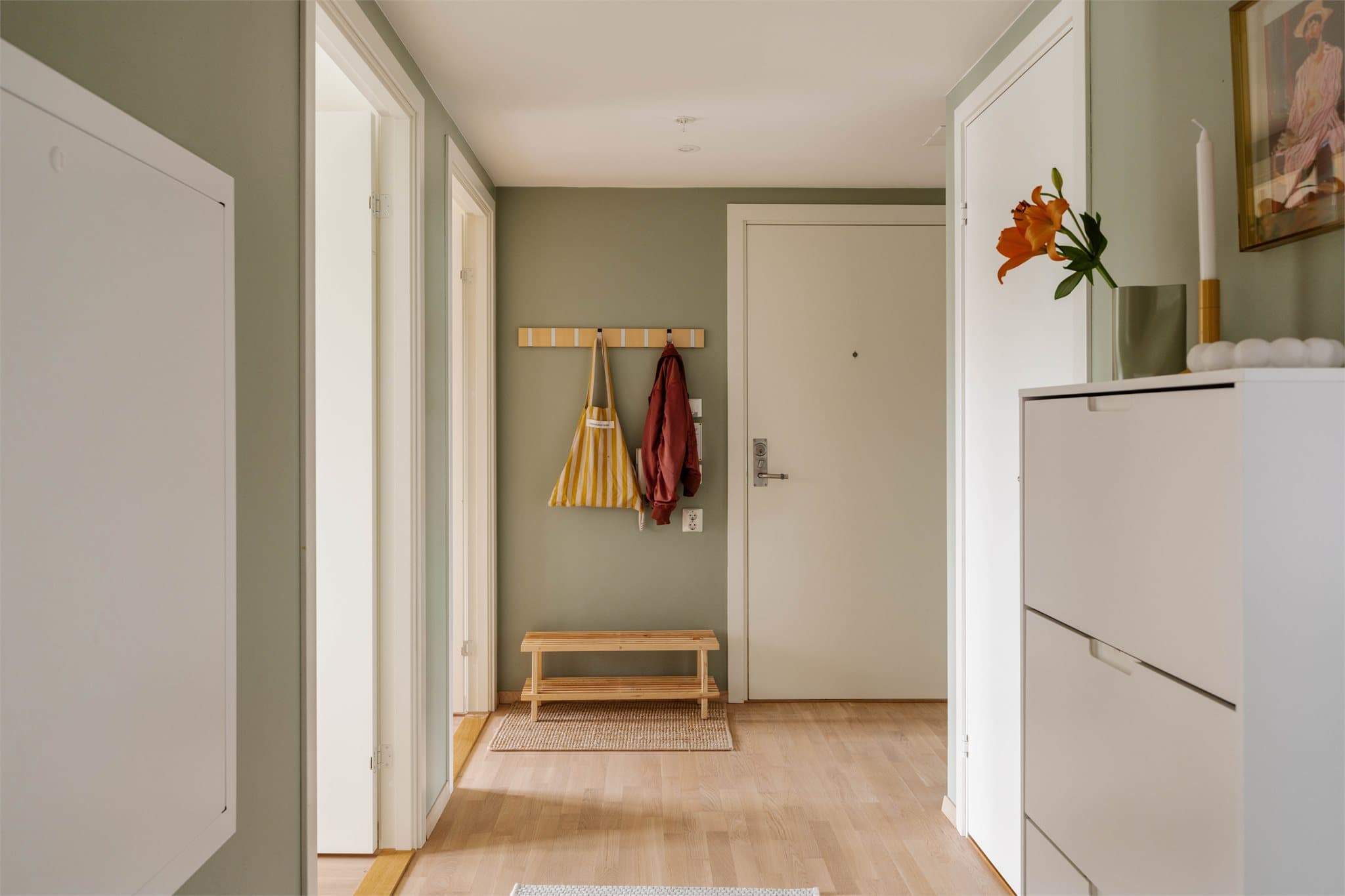 Romslig og innbydende entré med en god atmosfære. Her er det plass til oppbevaring og praktisk møblering, med både garderobeløsning og sittebenk.