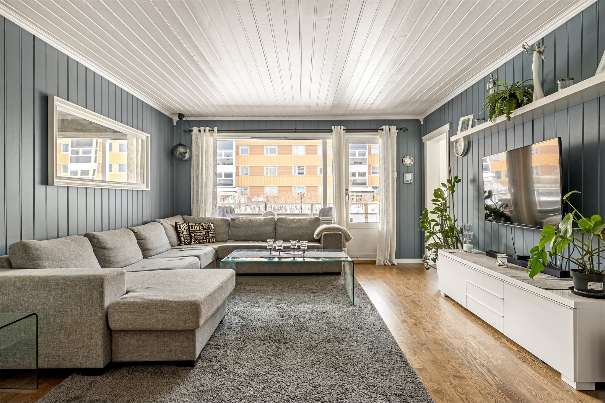 Lys og innbydende stue med store vindusflater.