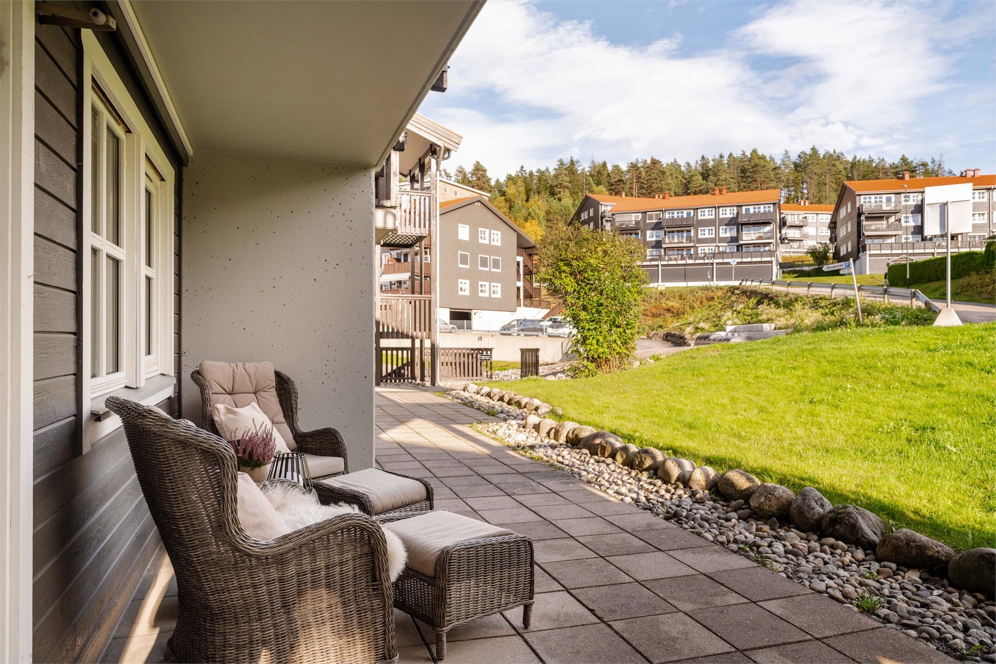 Delvis overbygd uteplass med plass til en komfortabel sittegruppe.