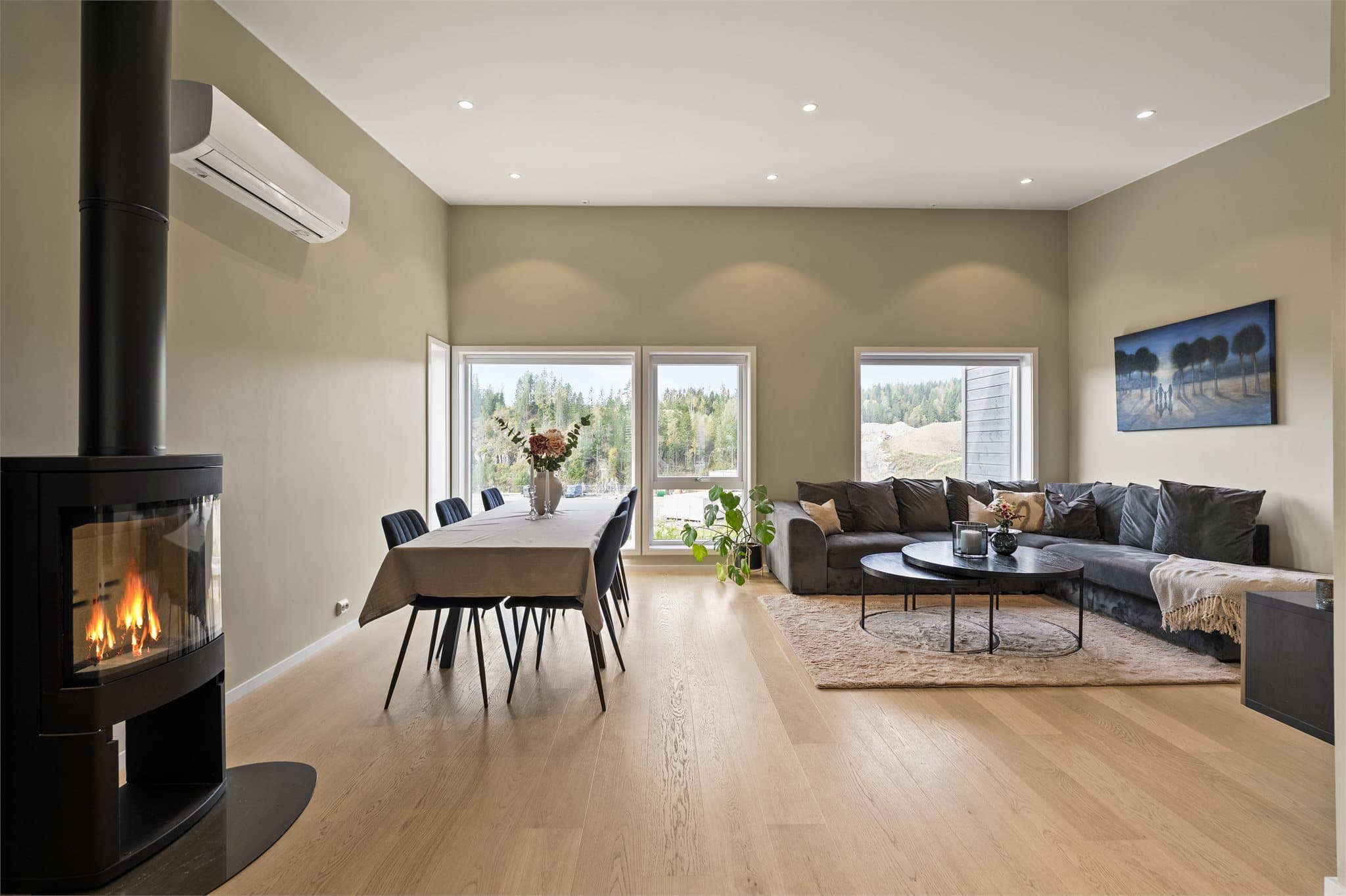 Romslig stue med store vindusflater slipper inn rikelig med naturlig lys, noe som gir rommet luftig preg.