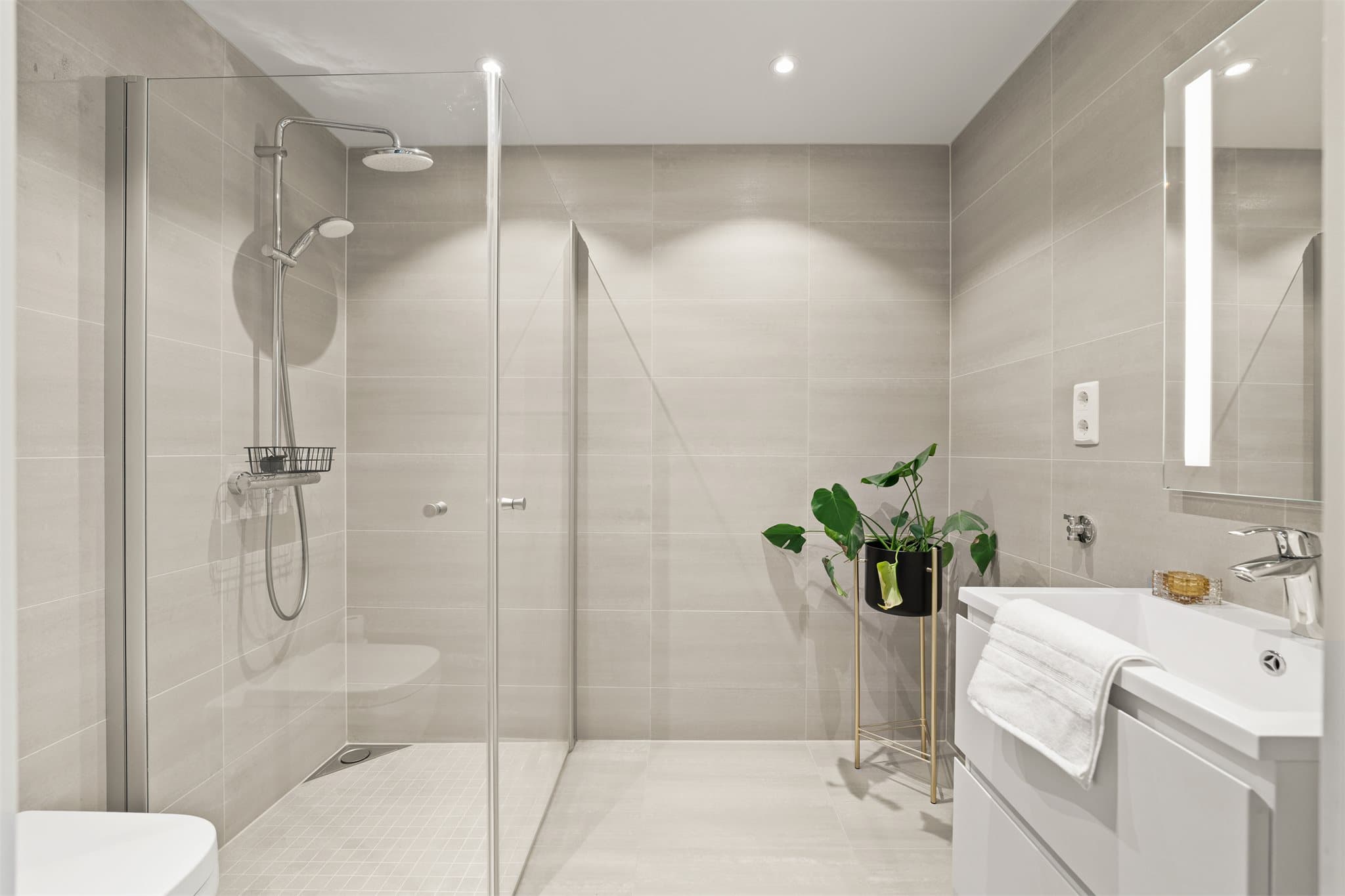 Lekkert baderom med gulvvarme. Rommet er innredet med vegghengt toalett, tidløs baderomsinnredning og dusjhjørne med regnfallsdusj.