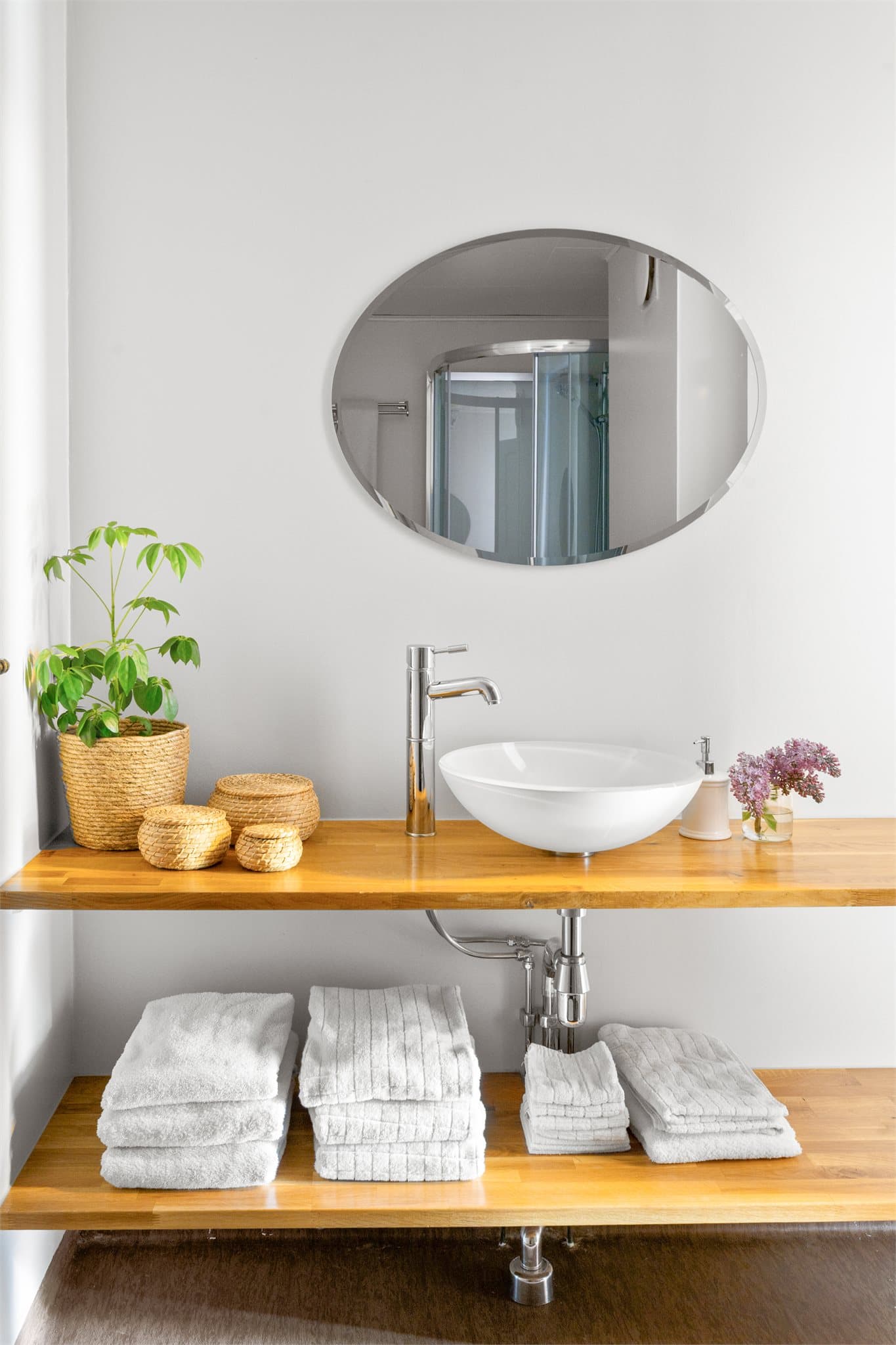 Badet har glasservant på benkeplate, speil og belysning.