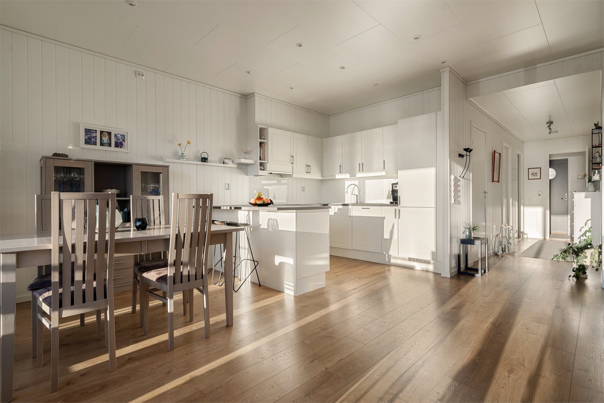 Lyst og tidløst kjøkken med integrerte hvitevarer samt rikelig skap- og benkeplass.