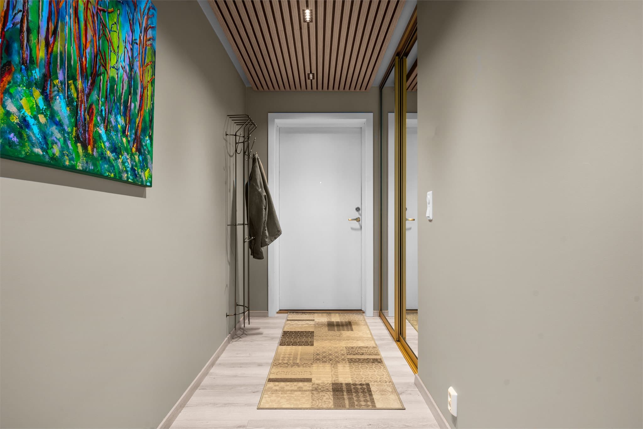Entreen har skyvedørsgarderobe med speilfronter og det er montert spiler med downlights i himling.