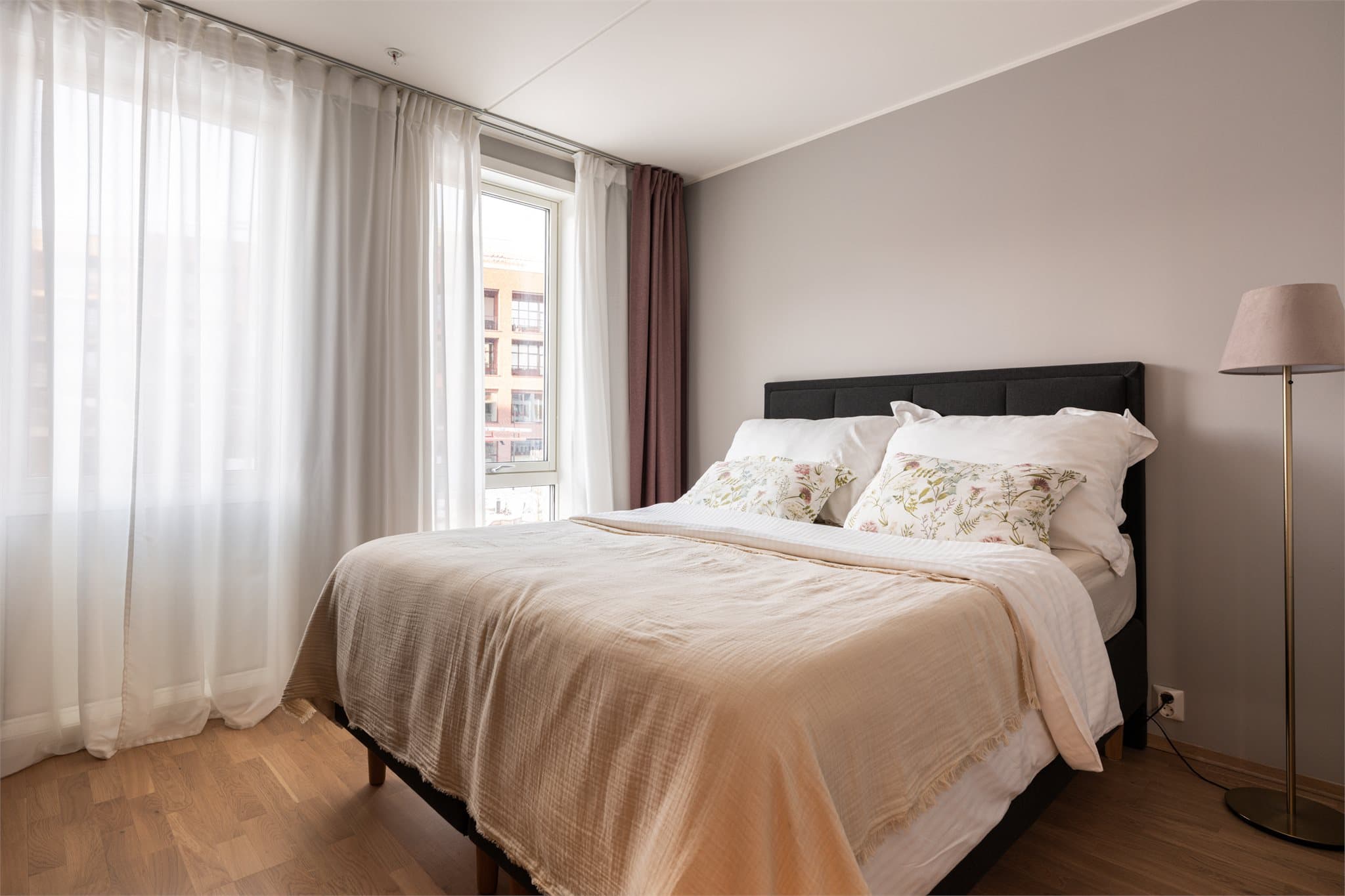 Luftig hovedsoverom med plass til dobbeltseng og nattbord på sidene.