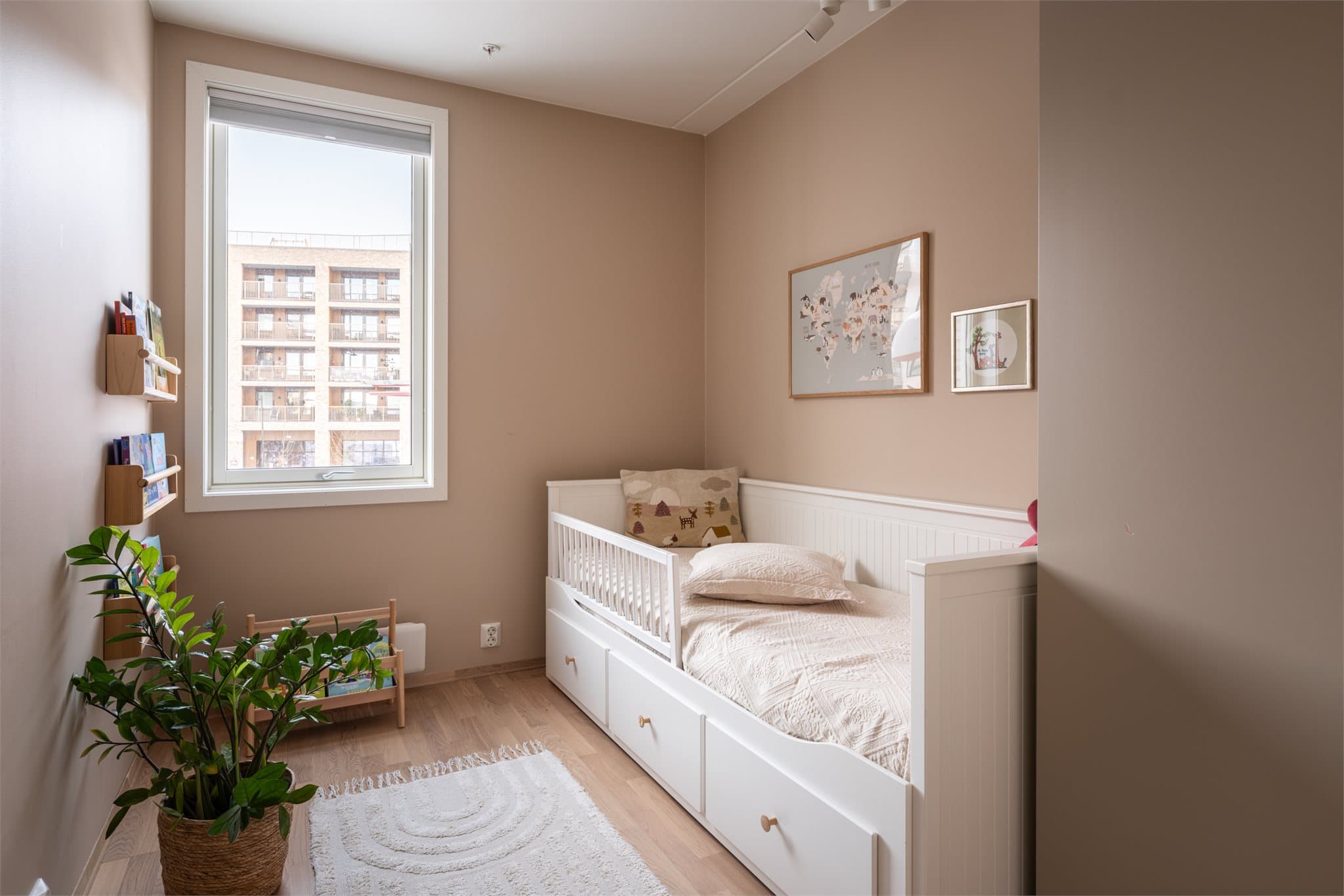 Innbydende barnerom med plass til seng, skrivepult og lekeplass.
