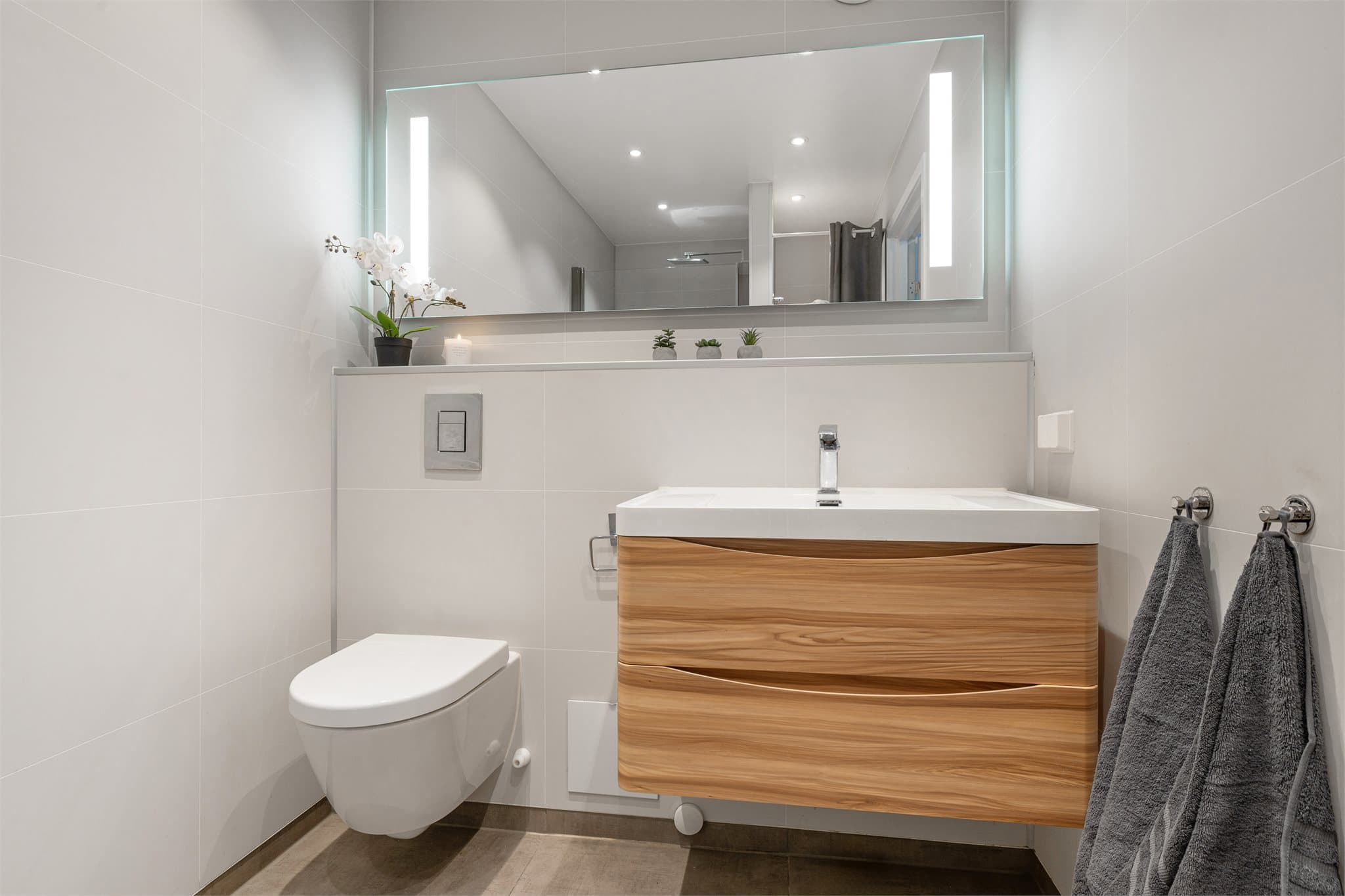 Badet ble pusset opp i 2020 med våtromsplater på vegg, flislagt gulv og ny innredning.