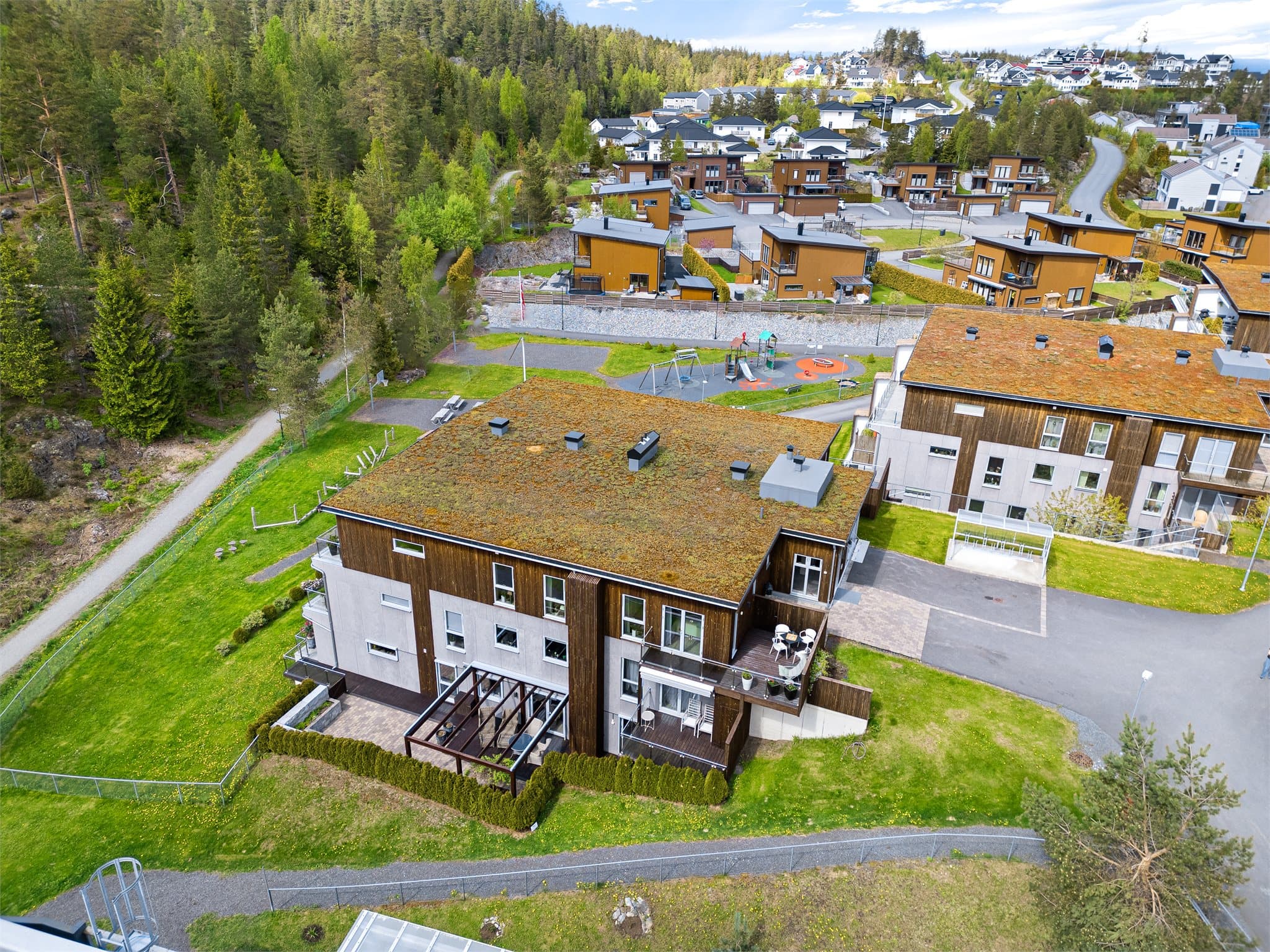 Bygget har et moderne uttrykk med stilrene fasader og grønne takflater beplantet med sukkulenter og variert vegetasjon, noe som gir et eksklusivt og harmonisk preg samtidig som det glir naturlig inn i omgivelsene.