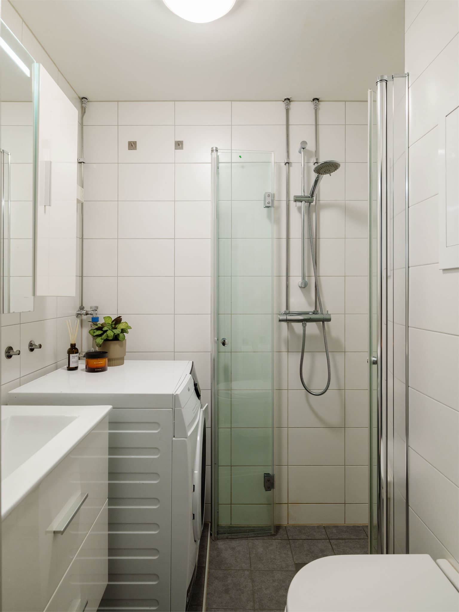 Badet er innredet med vegghengt toalett, servantmøbel, dusjhjørne og det er opplegg for vaskemaskin.