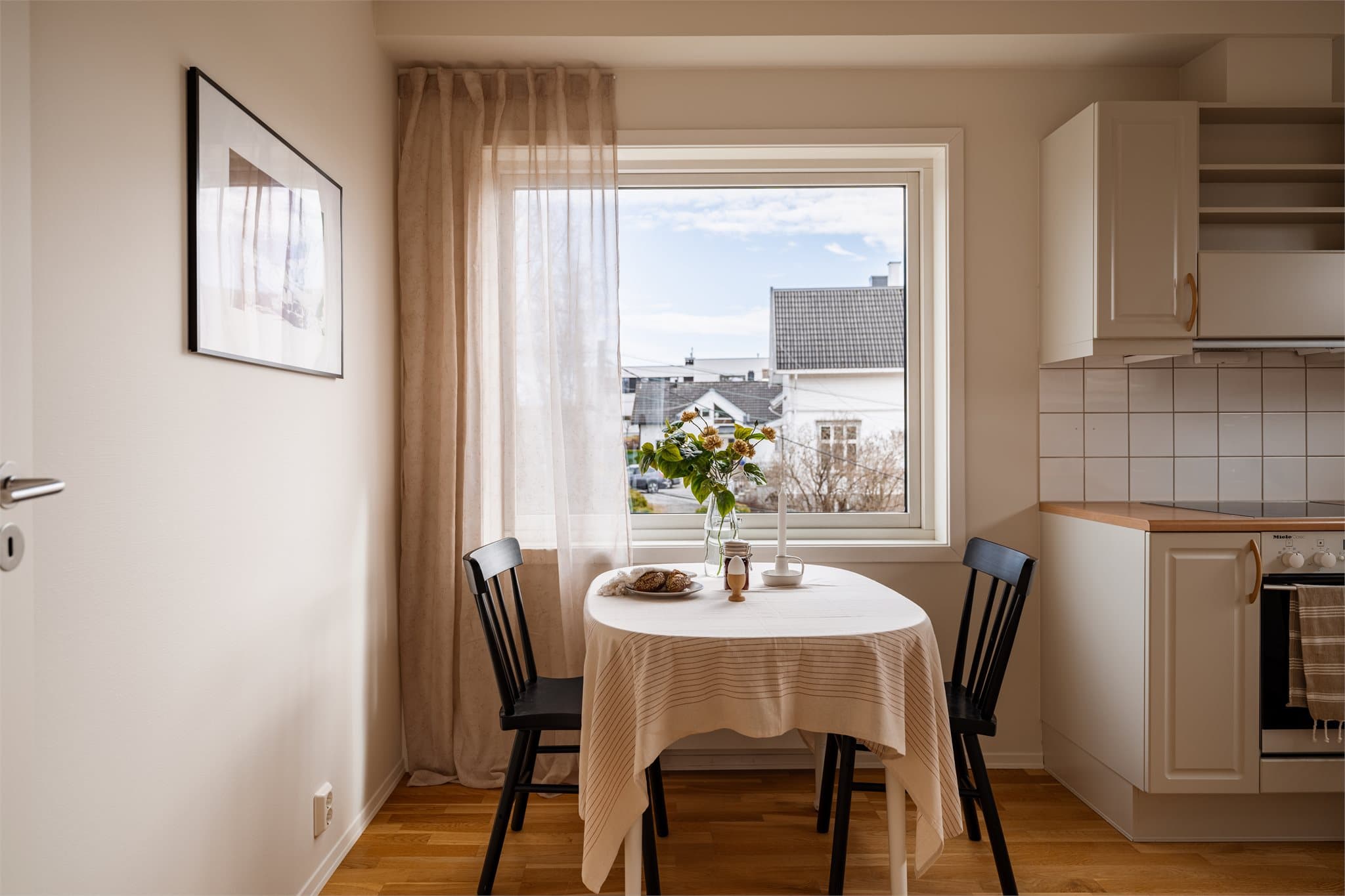 Videre inn i leiligheten finner man kjøkkenet, med plass til et hyggelig frokostbord ved vinduet.
