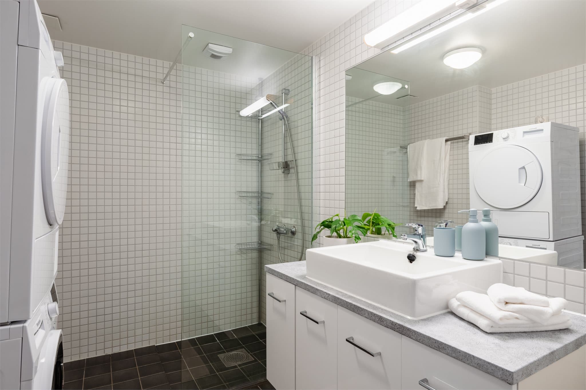 Romslig, flislagt bad med elektrisk gulvvarme for god komfort. Det er opplegg for vaskemaskin.