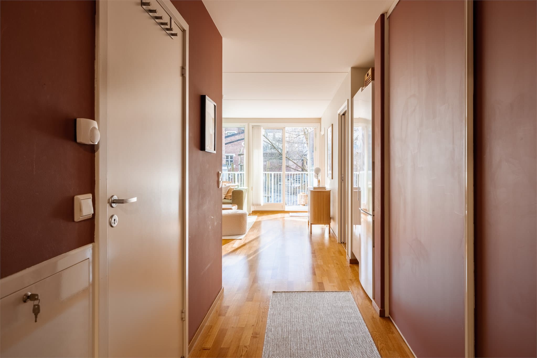 Fra entreen åpner leiligheten seg opp, med gjennomgående 3-stavs parkett som binder rommene sammen.