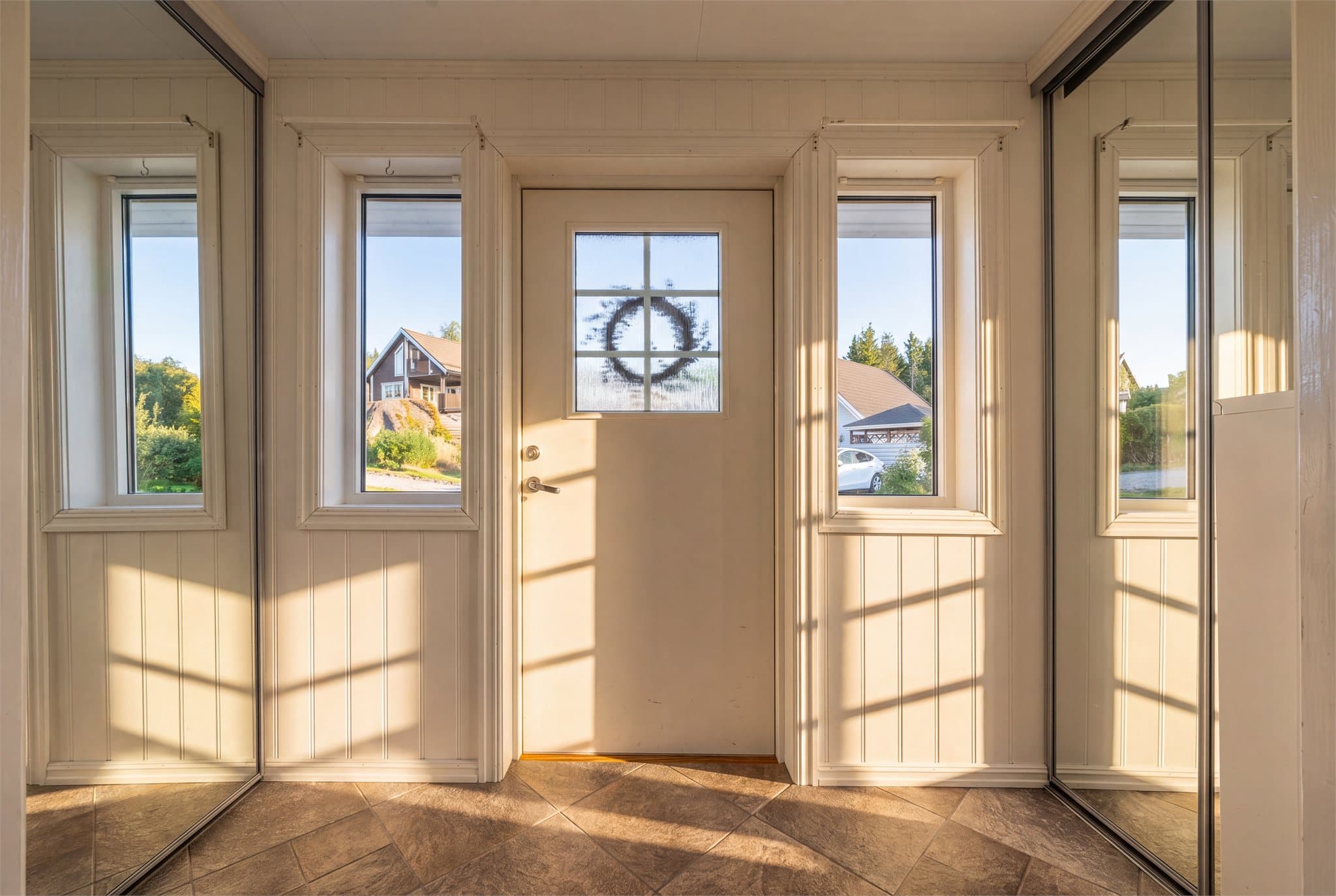 Stor påbygd entré/inngangsparti med skyvedørsgarderober på hver side