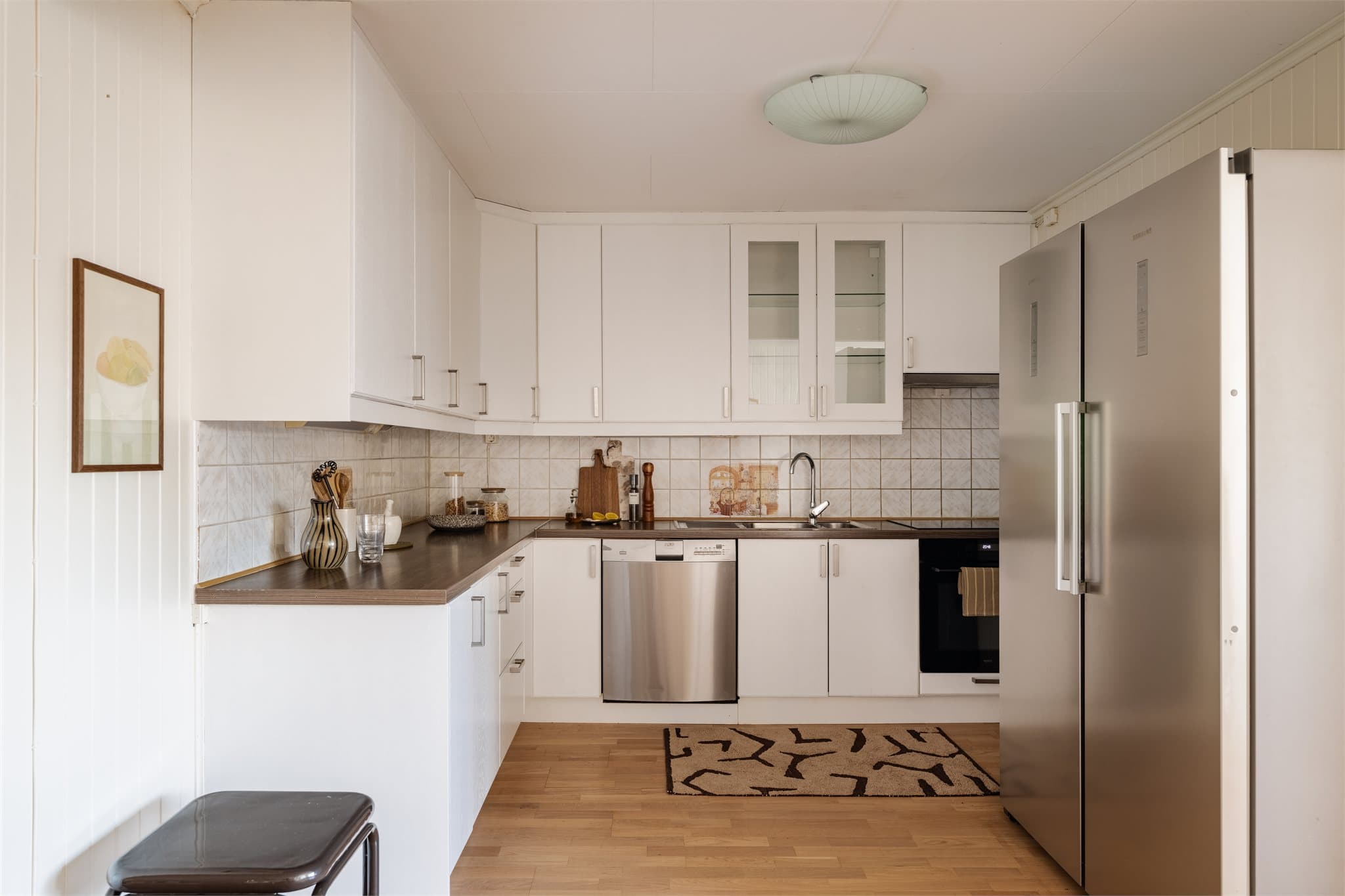 Innredningen har laminatbenkeplate med nedfelt oppvaskkum og plass til side-by-side kjøleskap.