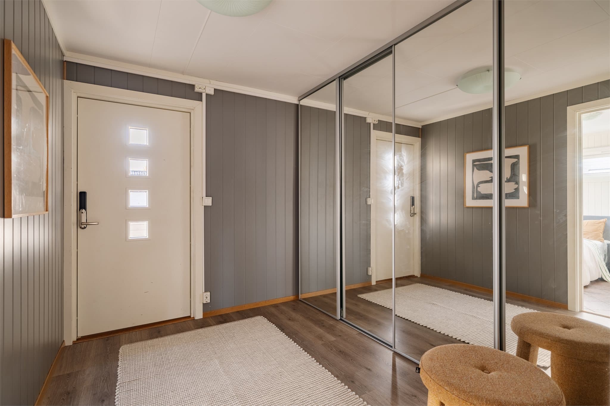Entréen har skyvedørsgarderobe med speilfronter for oppbevaring av yttertøy og sko.