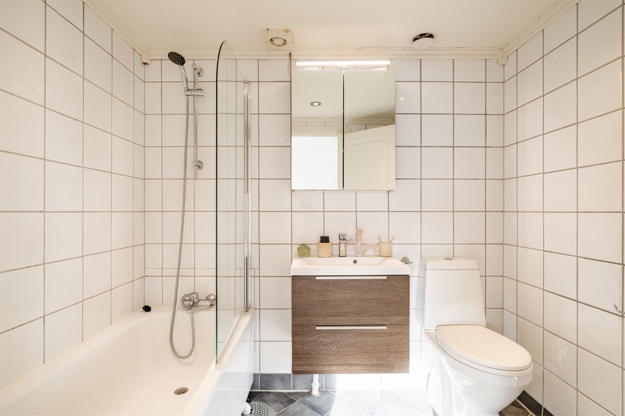 Badet i andre etasje har flislagte flater, varmekabler i gulvet, badekar med glassvegg og servantmøbel.