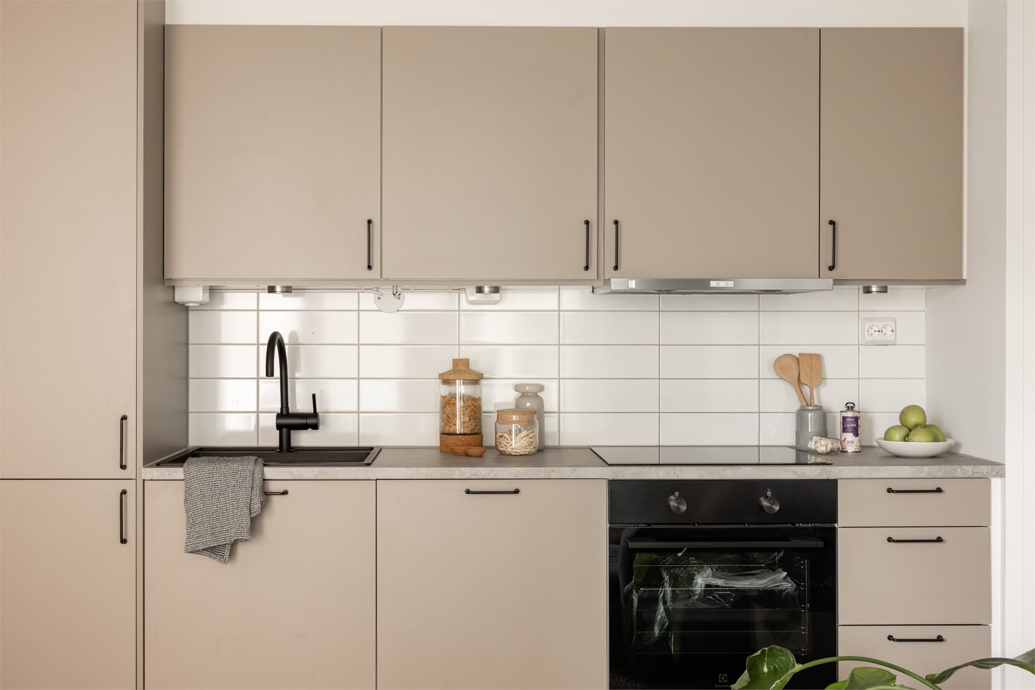 Lekkert og lyst kjøkken med godt med skap og benkeplass.