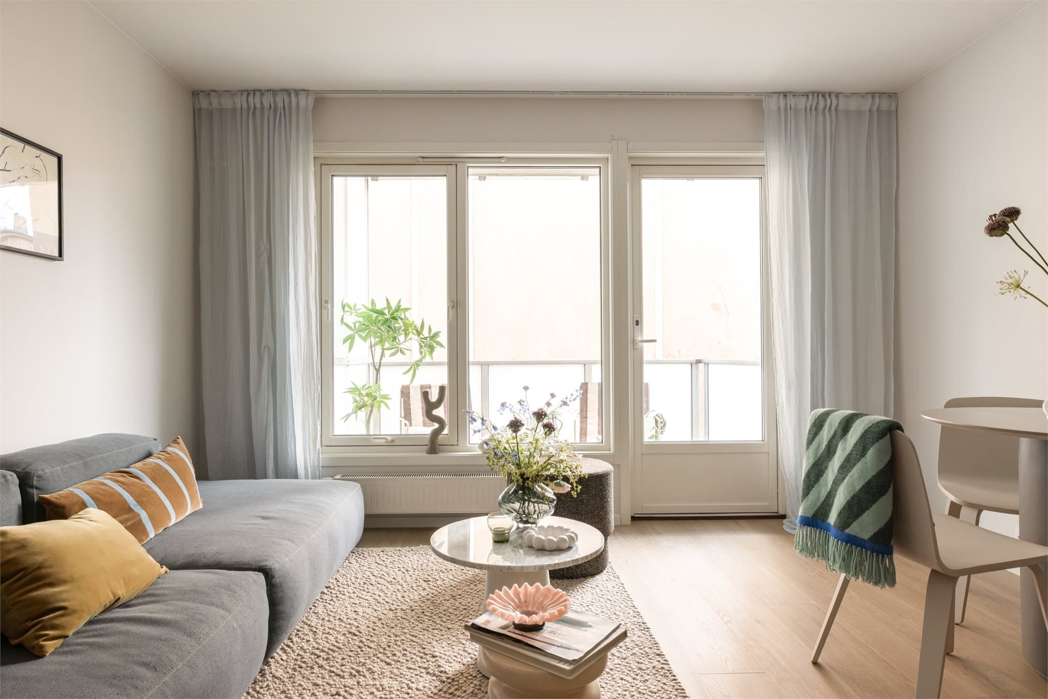 Romslig stue med store vinduer som gir mye naturlig lys.