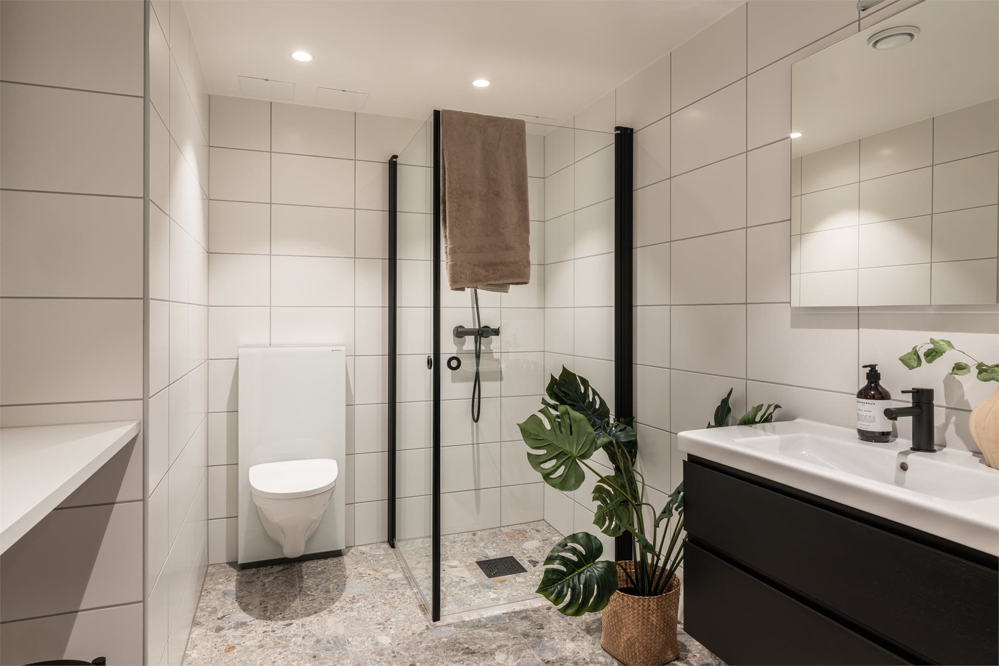 Dusjhjørne med innfellbare glassdører gir en arealeffektiv løsning.