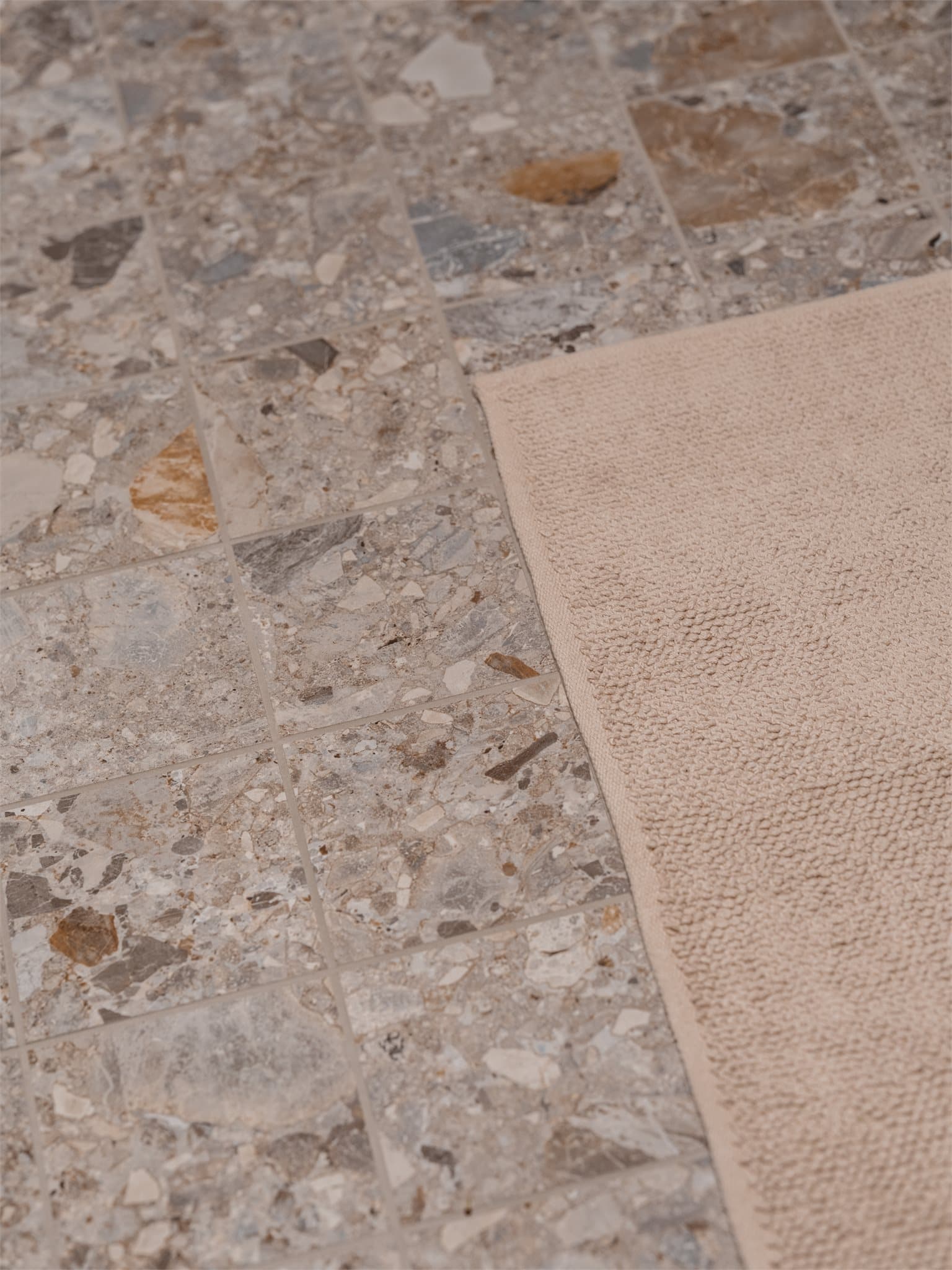 Terrazzoflisene på gulvet gir badet et eksklusivt særpreg og en moderne følelse.