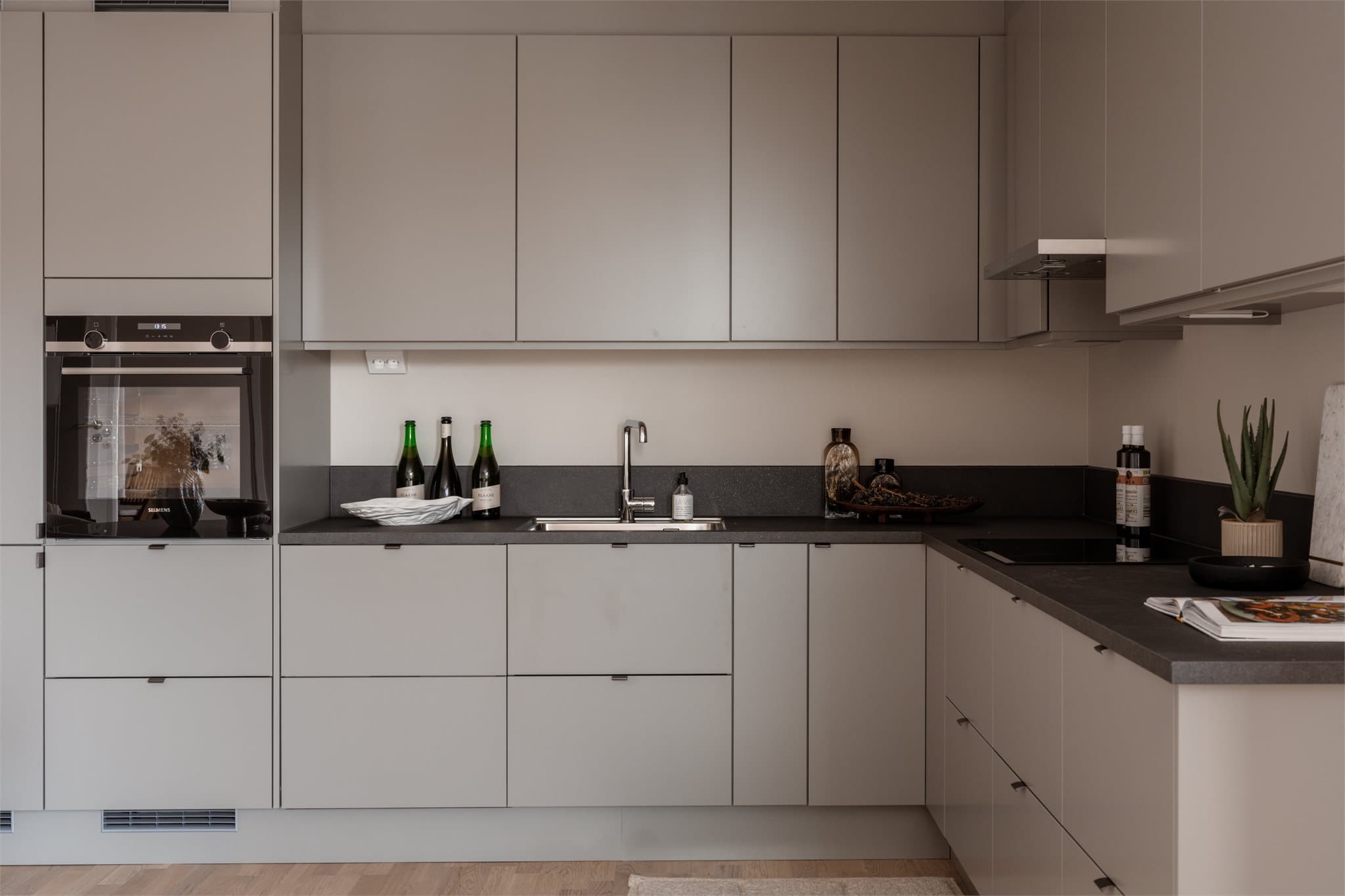 Mørk benkeplate i laminat gir en fin kontrast til de lysere, grå skapfrontene.