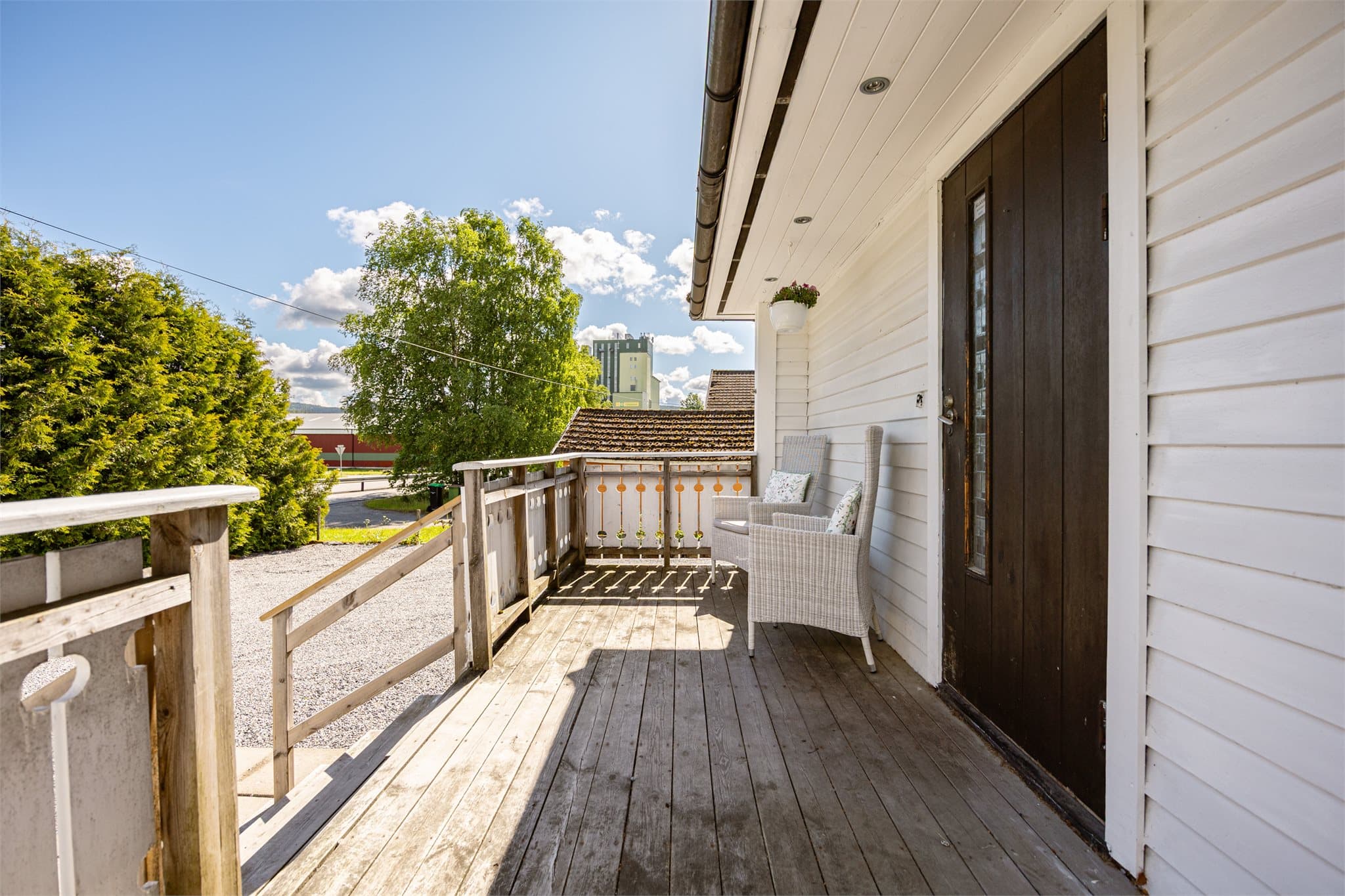 Velkomstverandaen ved inngangspartiet har plass til sittegruppe – et fint sted for en rolig kaffepause.