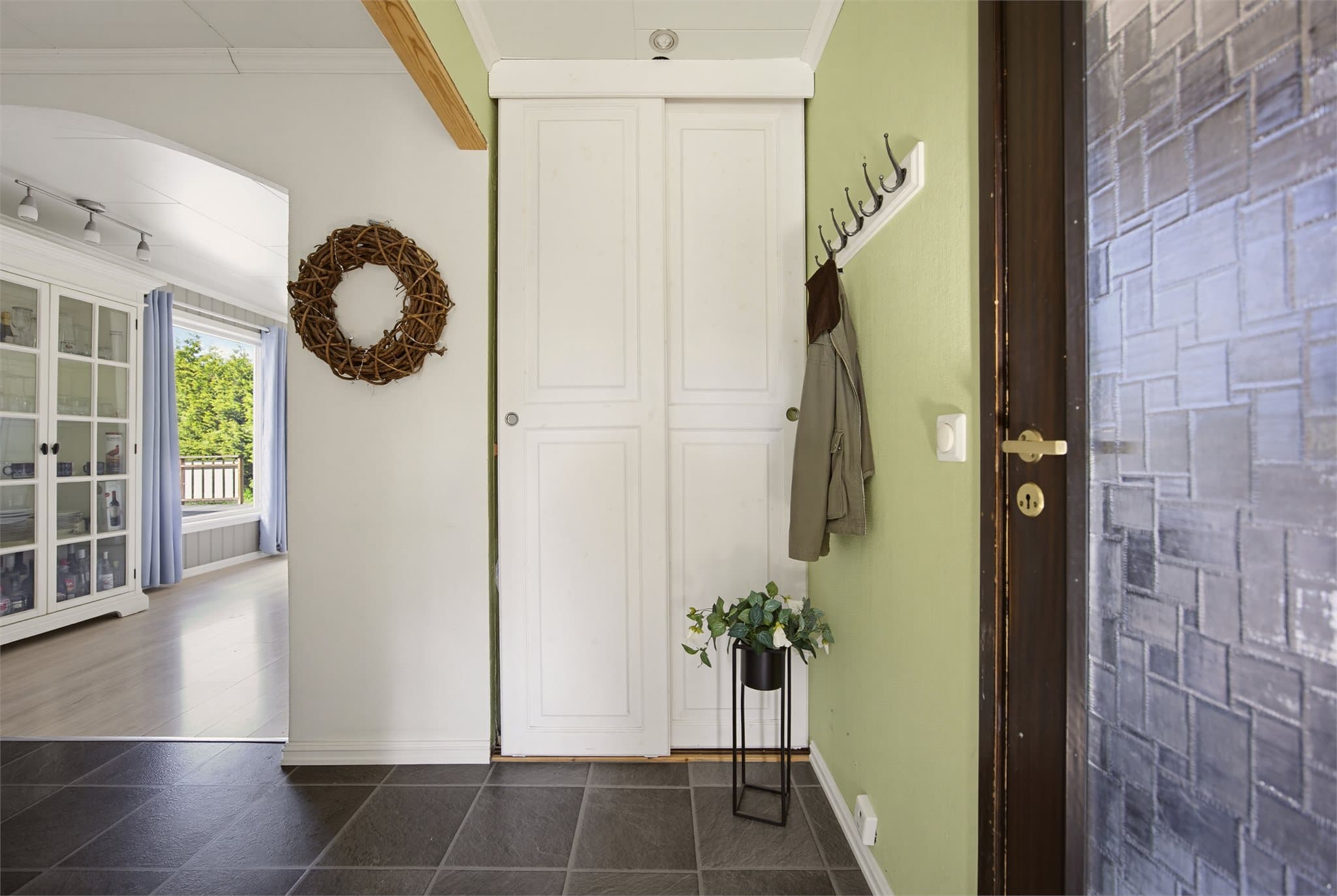 Fra entreen kommer man videre inn til gang med skyvedørsgarderobe.