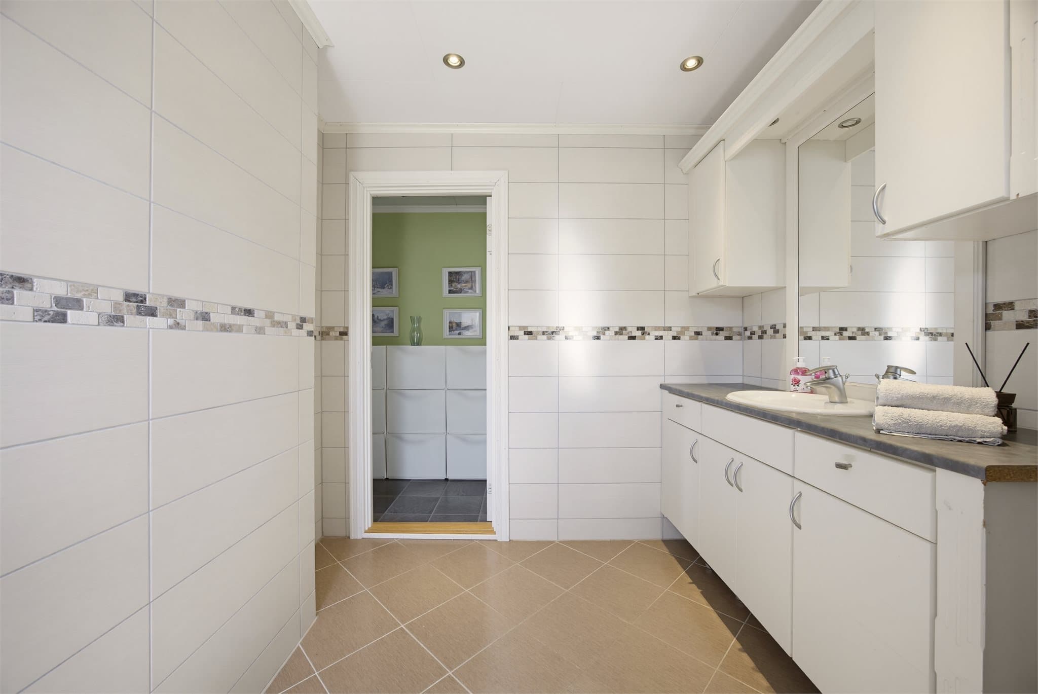 Badet er innredet med servantinnredning, dusjkabinett og toalett.