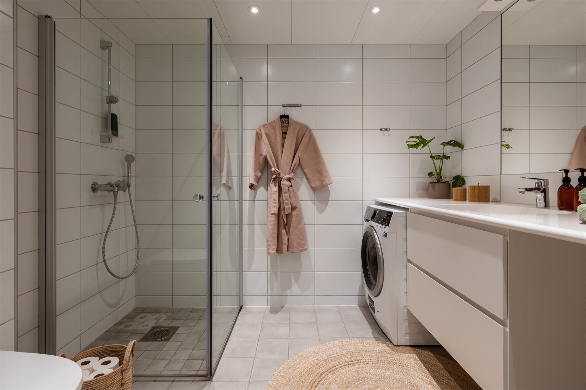 Lyst, flislagt baderom med varme i gulv og downlights i himlingen.