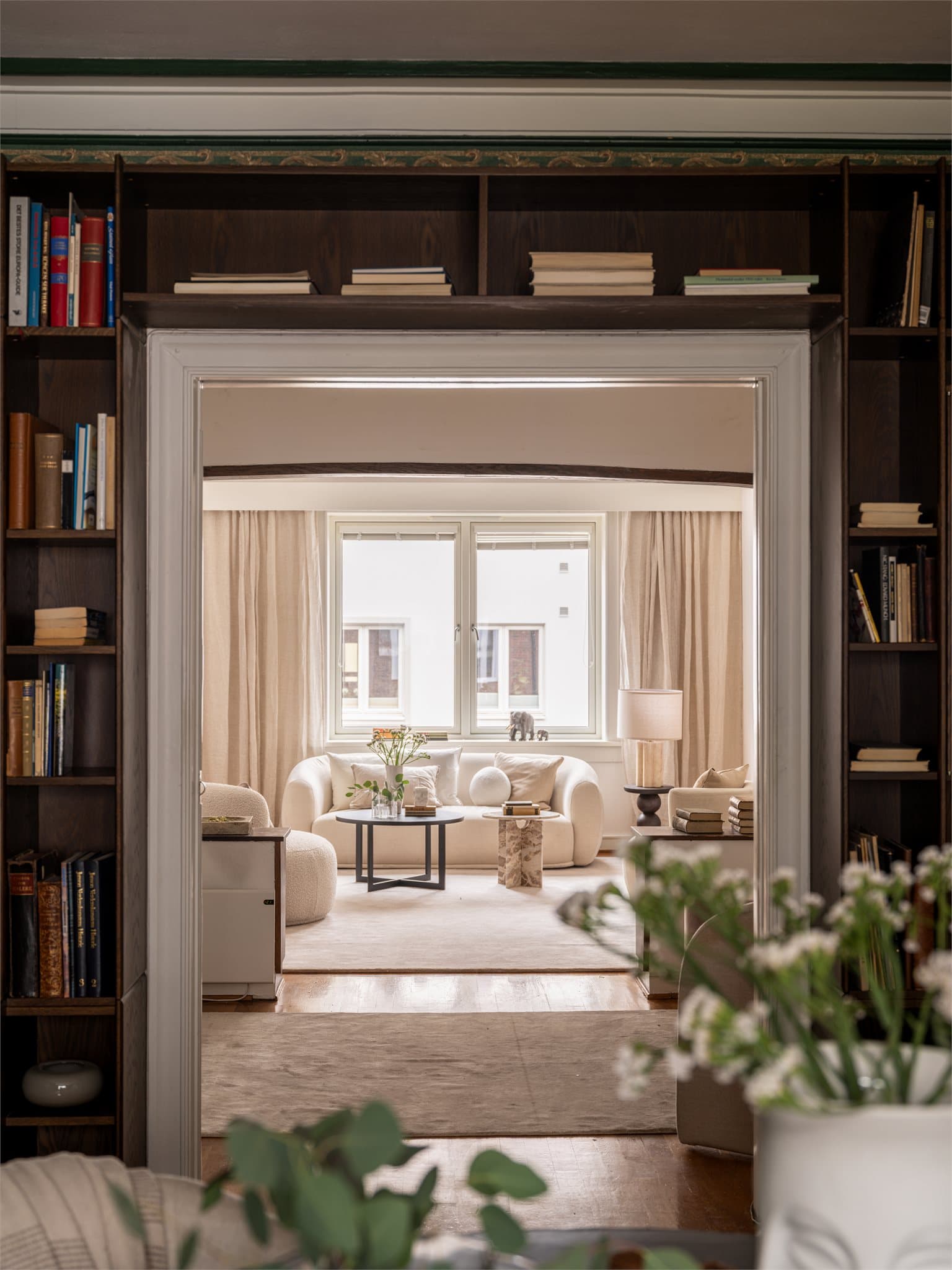 Flotte klassiske detaljer med integrerte bokhyller som rammer inn åpningen mellom rommene.