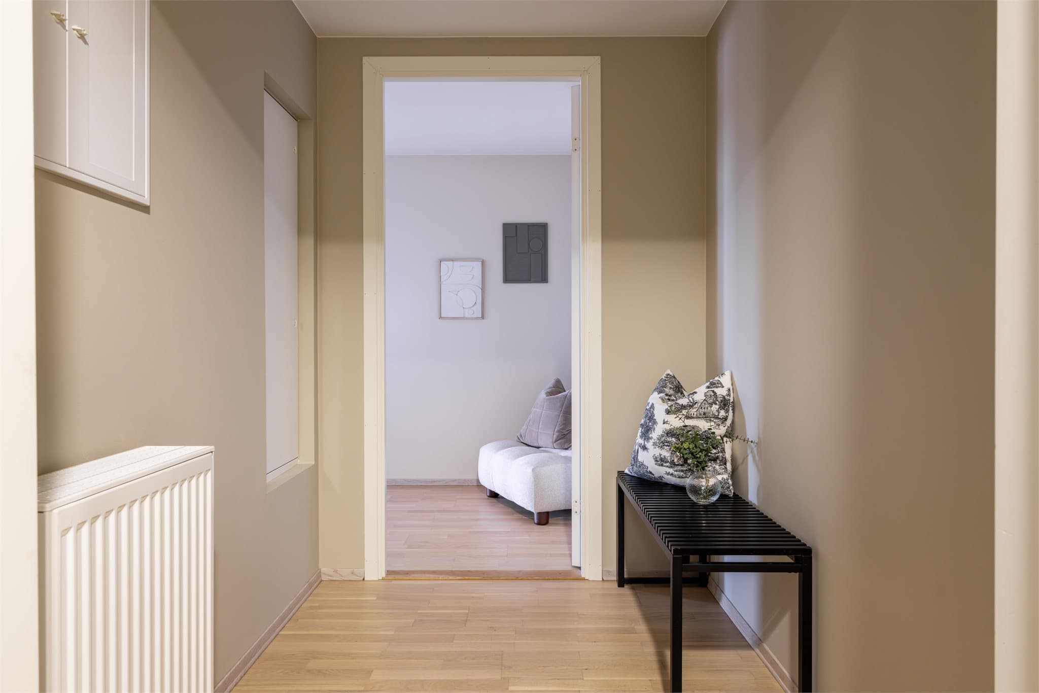 Velkommen inn i en lys entré med eikeparkett som er gjennomgående i boligen.