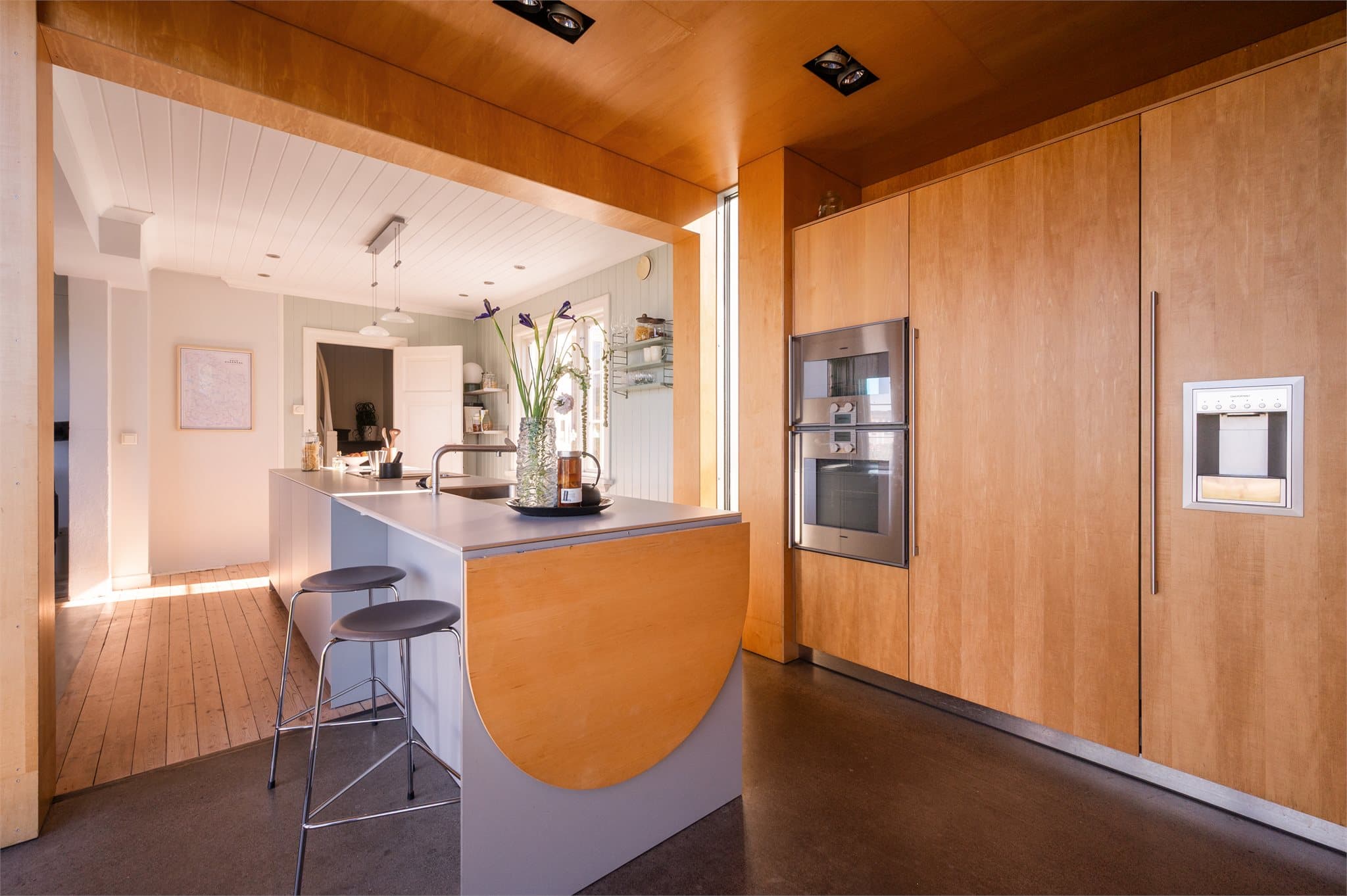 Stor kjøkkenøy med lysegrå fronter og laminat benkeplate.