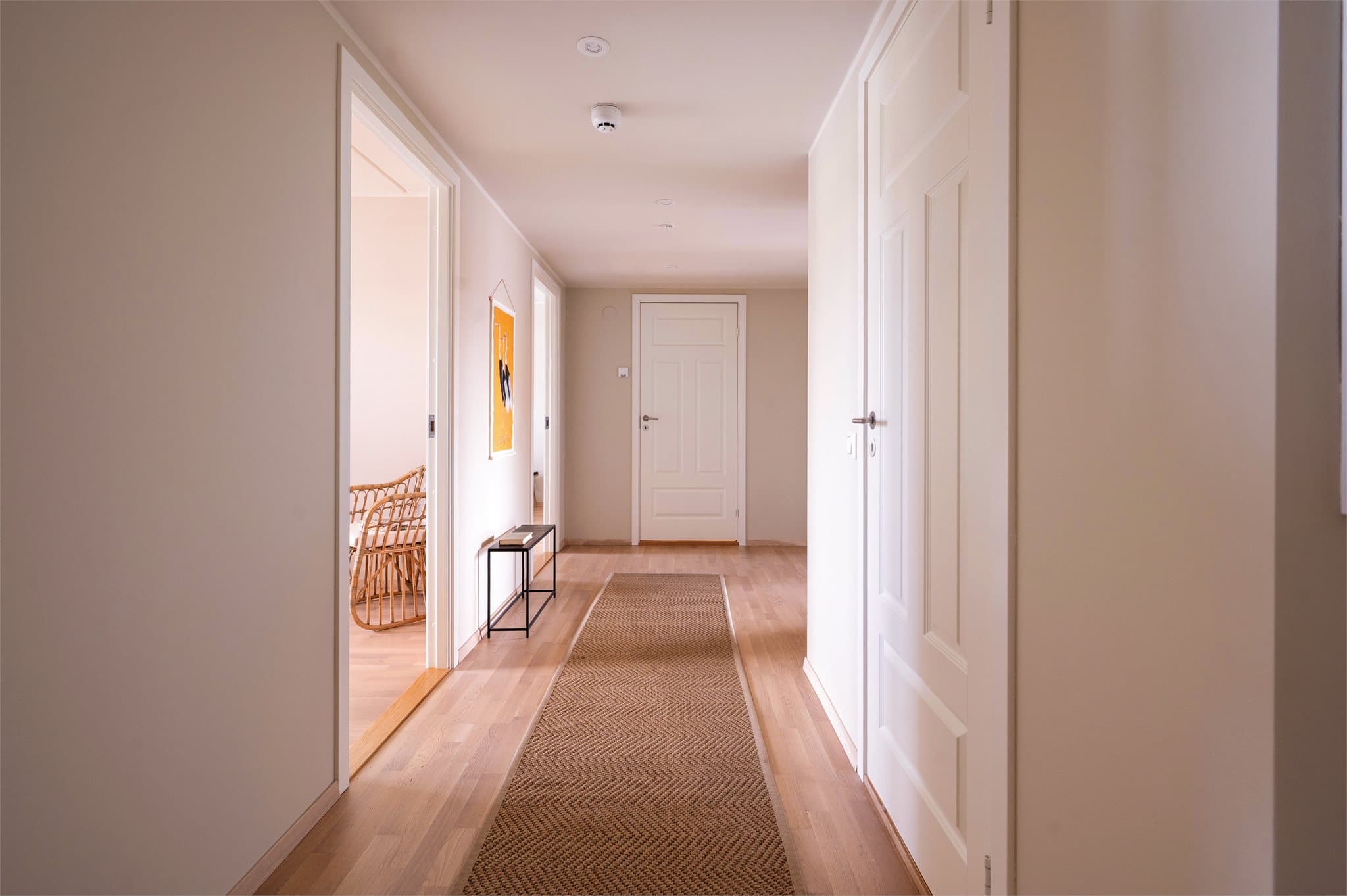 Overflater i parkett og nøytral fargepalett gir et ryddig og moderne uttrykk allerede ved inngang.