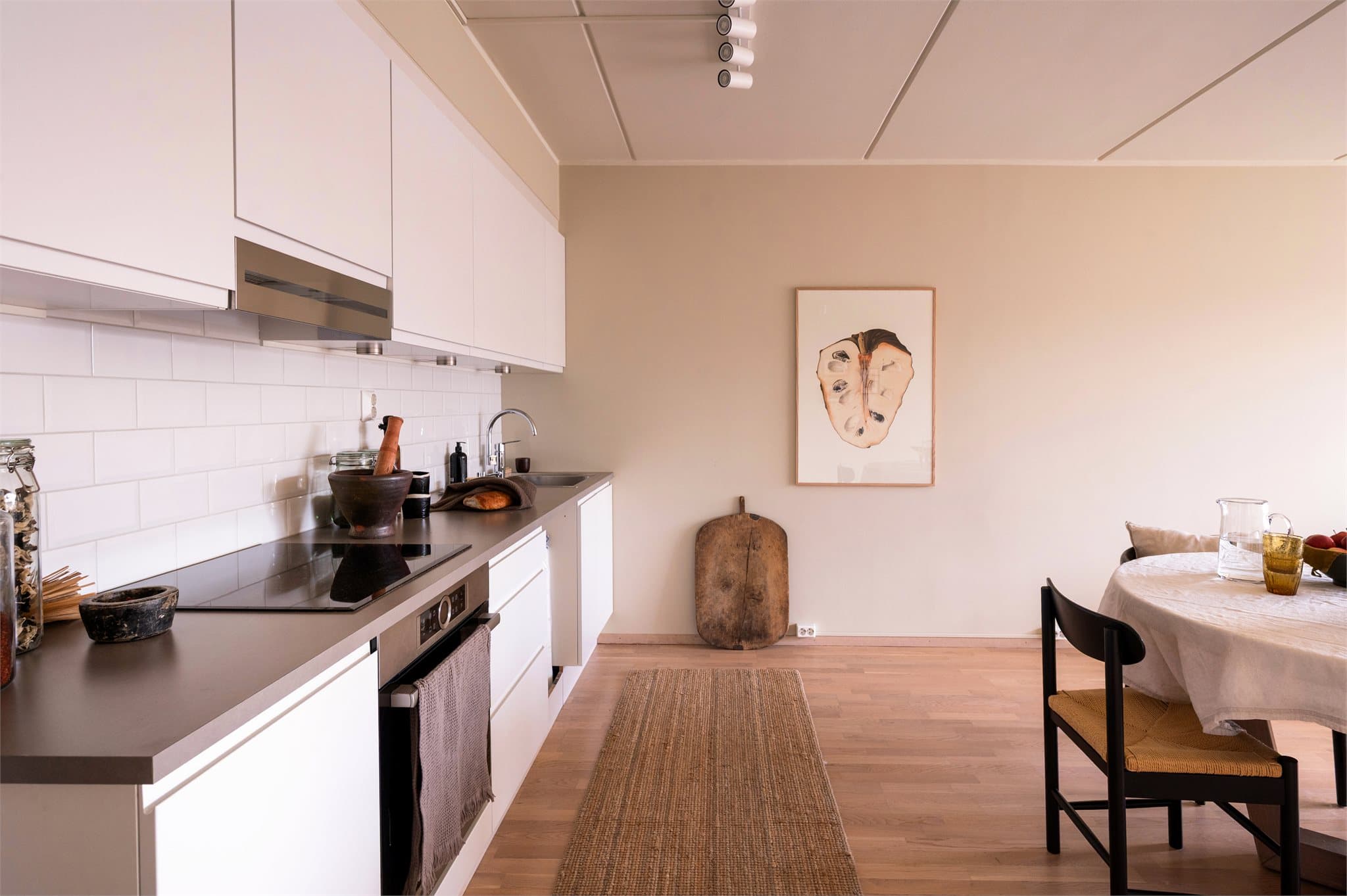 Innredningen er stilren med hvite glatte fronter, laminat benkeplate og nedfelt vask.