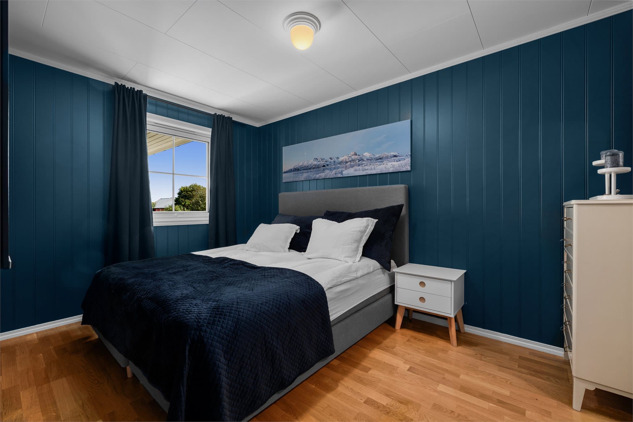 Romslig hovedsoverom i en moderne blåtone.