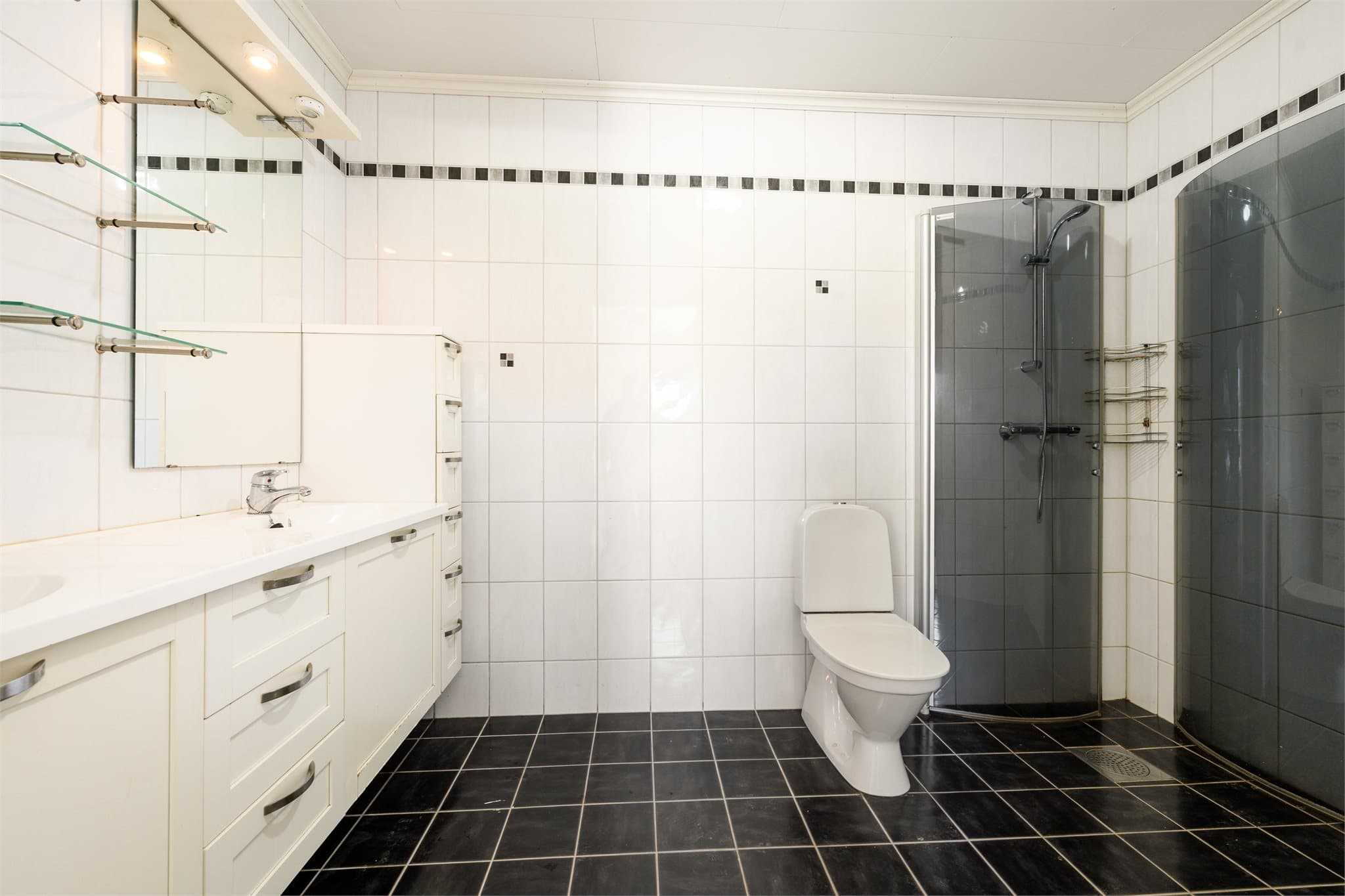 Dusjsonen er utstyrt med sotede, innfellbare dusjvegger i herdet glass, som gir et moderne preg og fleksibel bruk av rommet. Det er også opplegg for vaskemaskin og tørketrommel i vaskesøyle, som gir en praktisk og plassbesparende løsning i hverdagen.