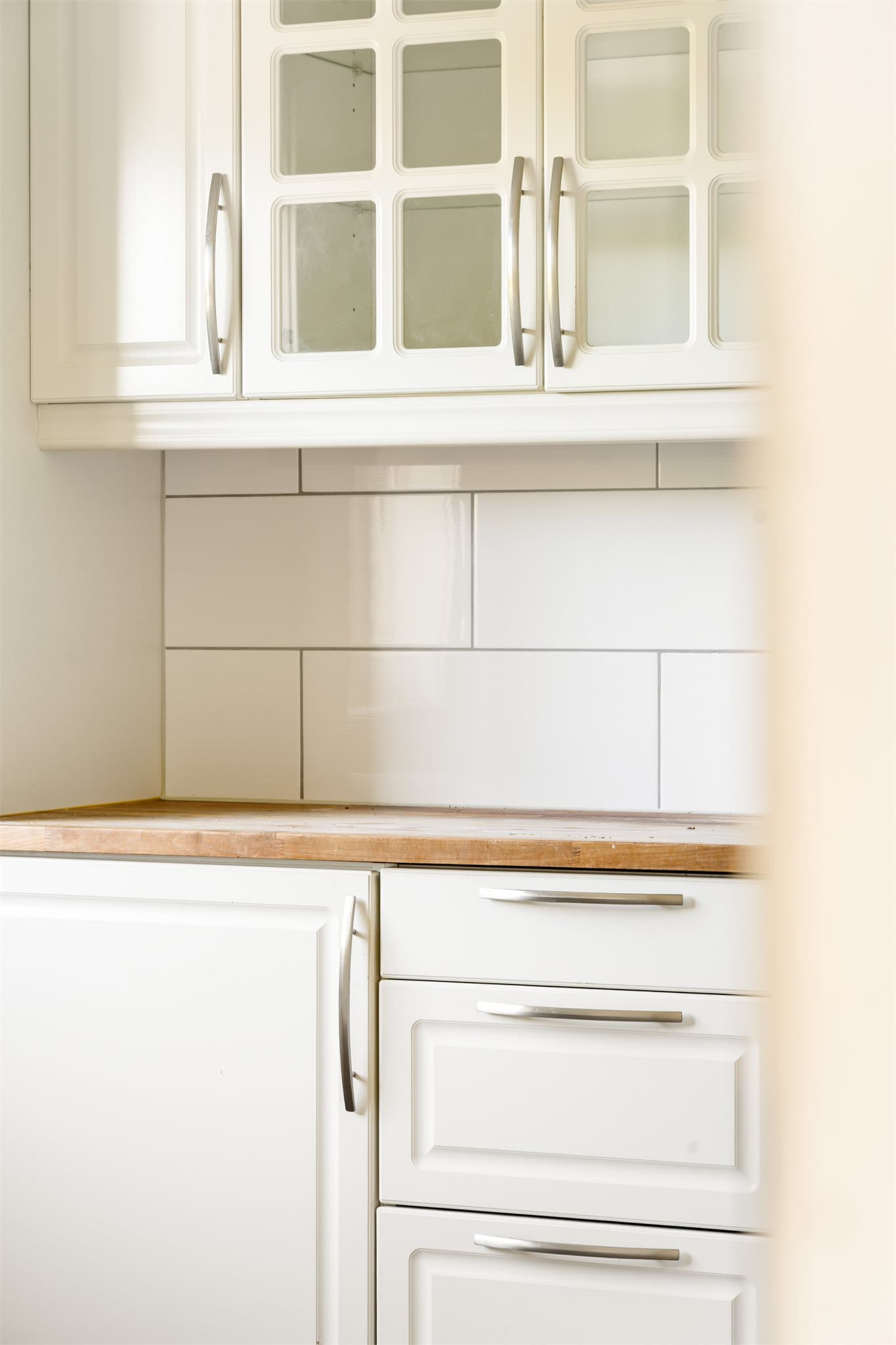 Innredningen har lyse, profilerte fronter som skaper en tidløs og hyggelig atmosfære. Dagens heltre benkeplate vil bli oppgradert med ny laminat benkeplate, noe som vil gi et moderne og lettstelt preg.