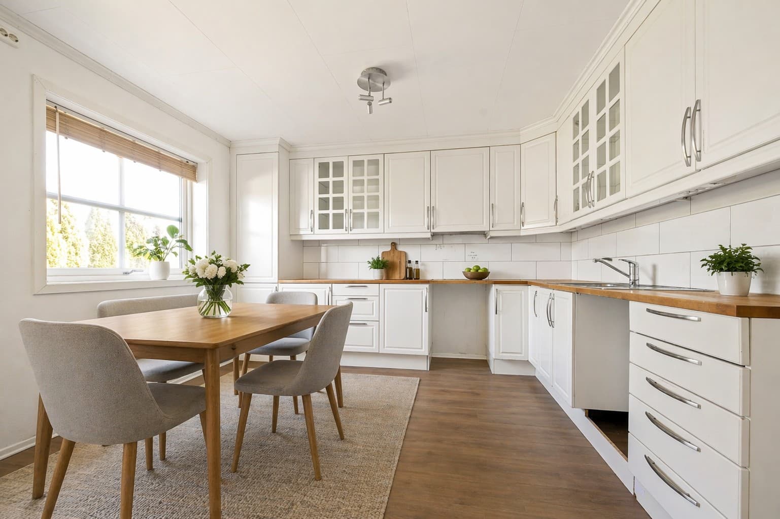 Ved kjøkkenvinduet er det god plass til spisebord, perfekt for hyggelige måltider i naturlig lys. Et praktisk og trivelig kjøkken med gode kvaliteter og fine oppgraderinger i vente. (Bildet er digitalt møblert)