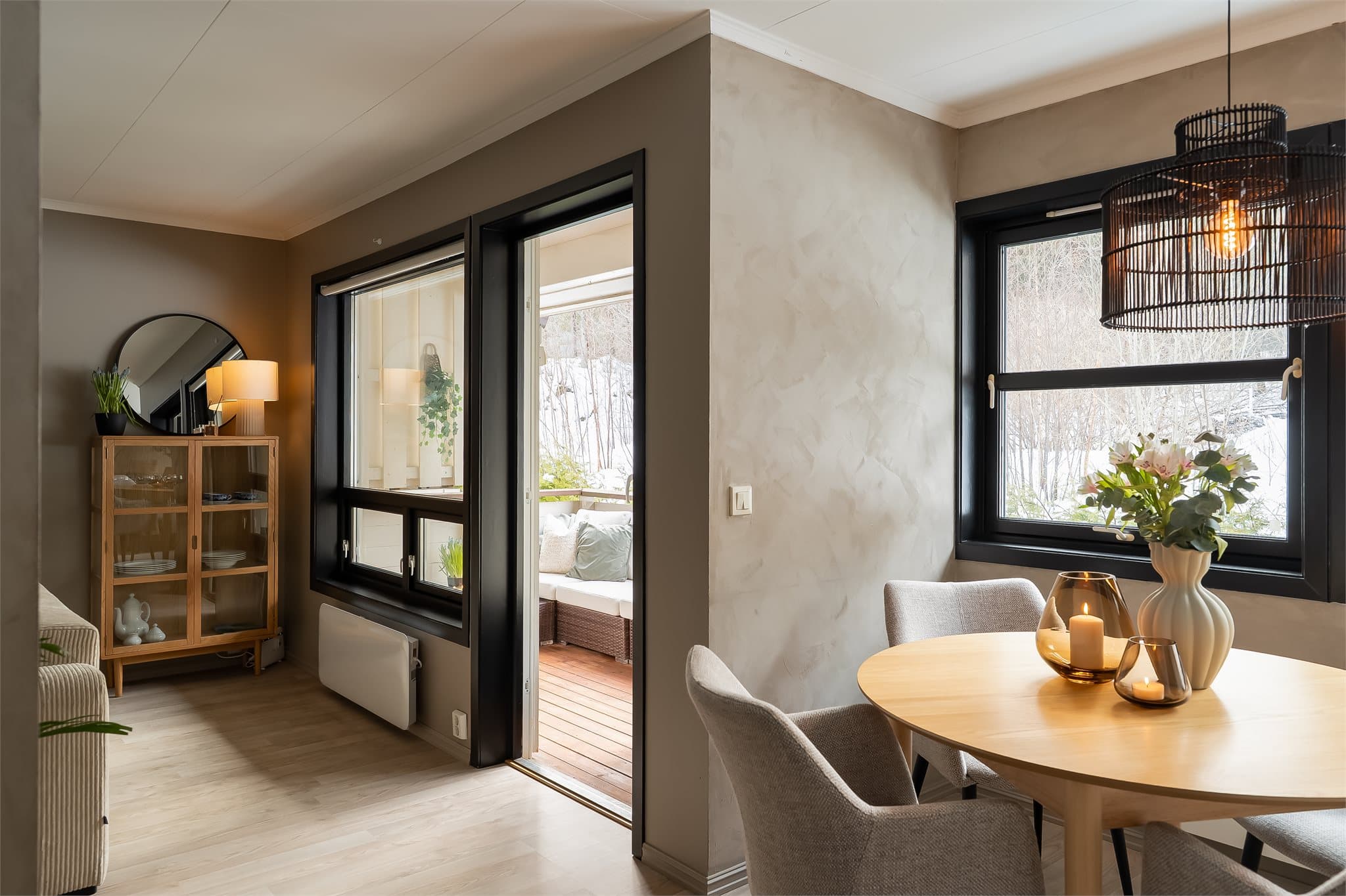 En lun spisestue med store vindusflater som slipper inn rikelig med lys.