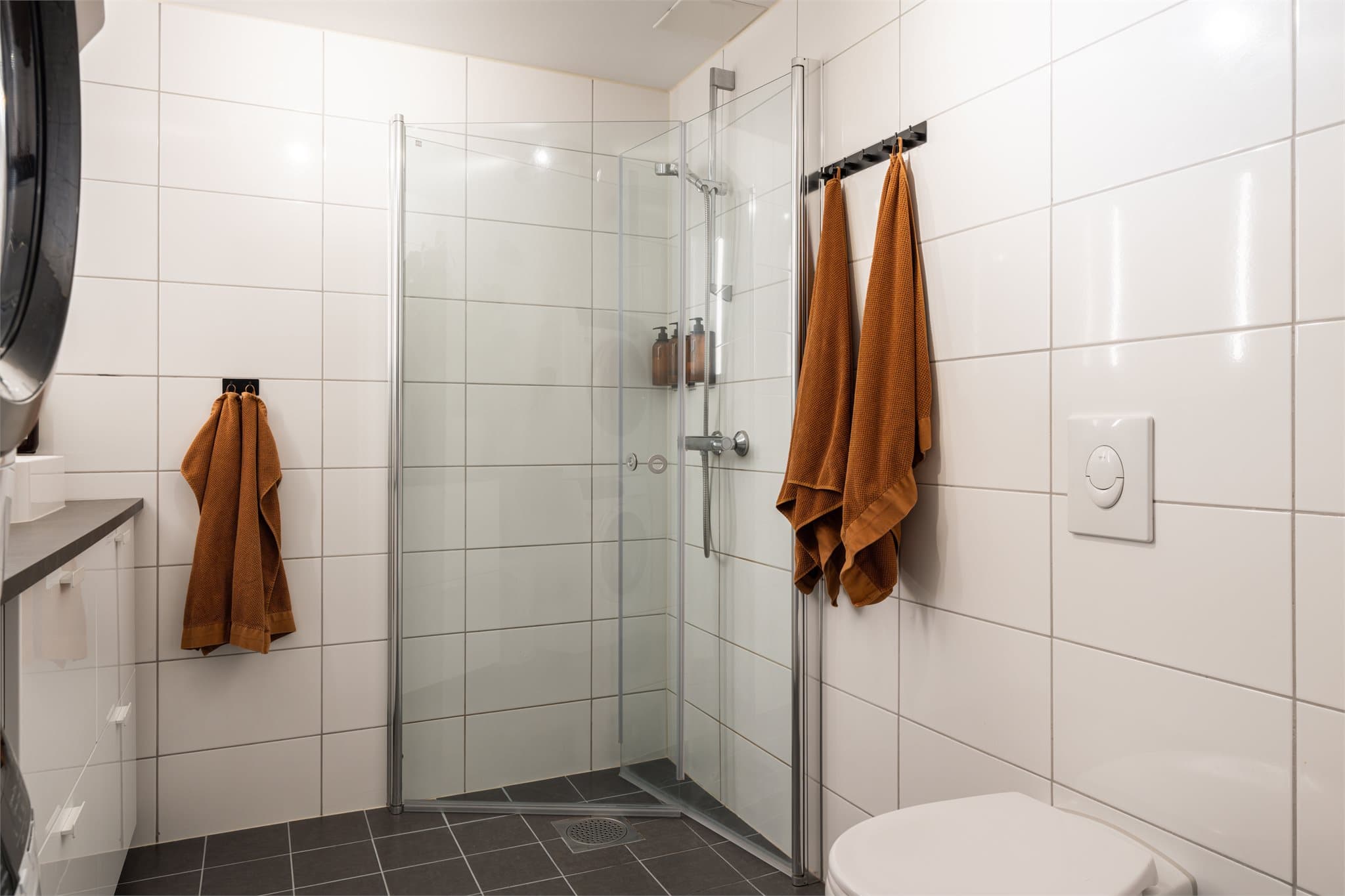 Badet har selvsagt varme i gulvet og dusjplass bak innfellbare dører.