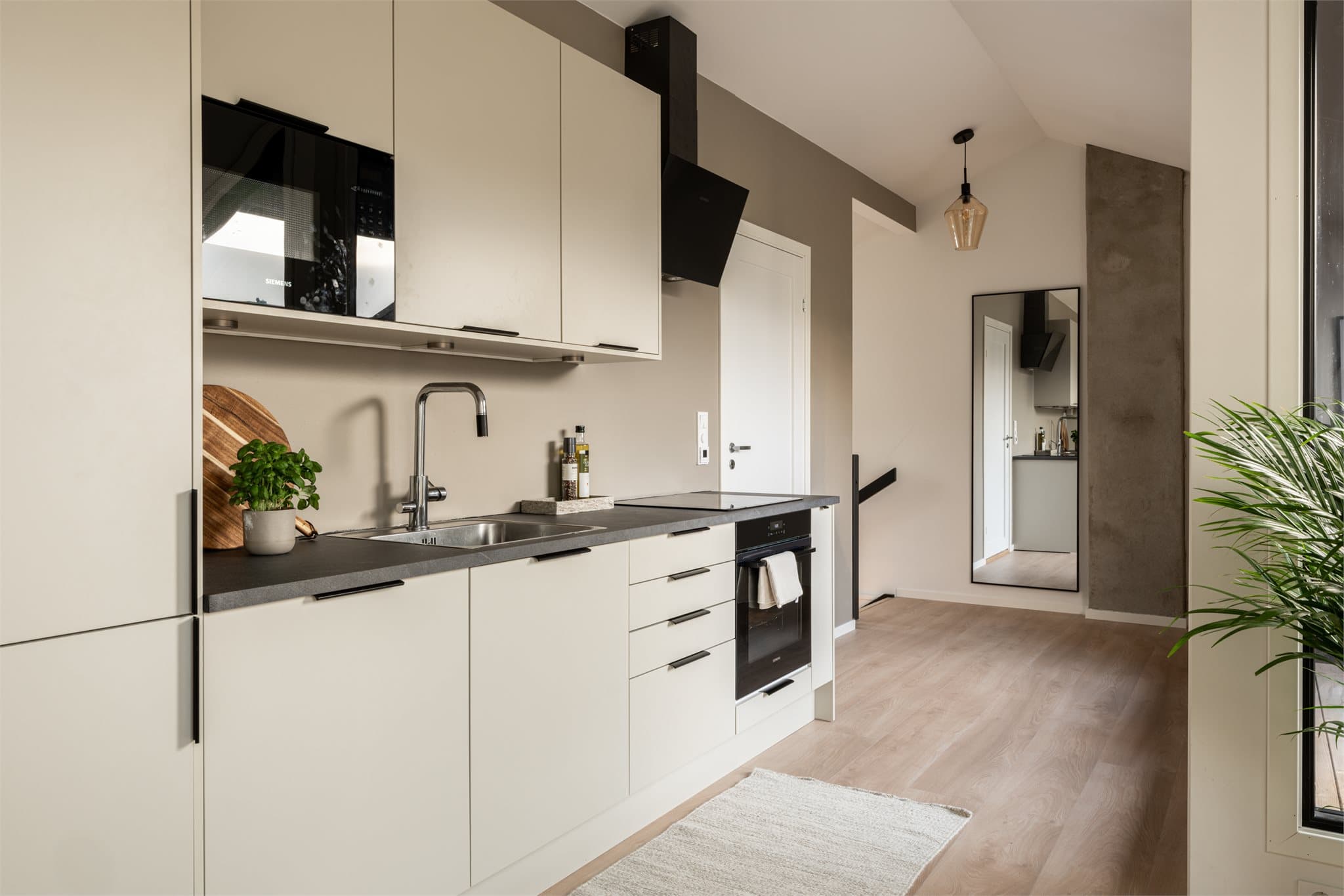 Kjøkkenet har moderne innredning med glatte skapfronter og laminat benkeplate.