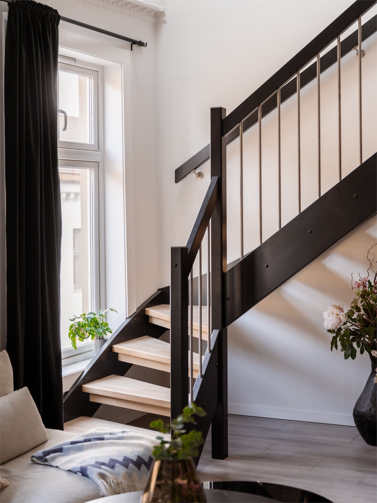 Tretrapp med malte vanger og åpne eik inntrinn mellom etasjene.